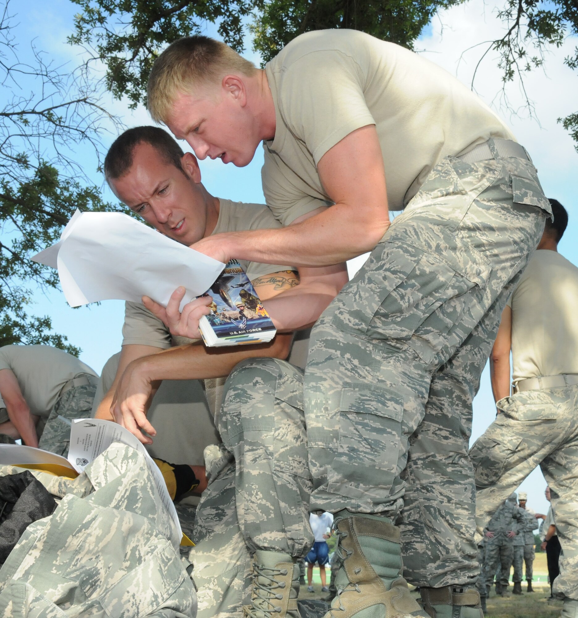 Fire Dawgs team members, Tech Sgt. Walter Shutler and Airman 1st Class Kyle Ledford, 81st Infrastructure Division, answer questions in the “reporting instruction quiz” challenge during the 81st Mission Support Group Ultimate Warrior Challenge June 1, 2012, at the Triangle Track at Keesler Air Force Base, Miss.  The teams are required to answer 16 questions correctly before moving on to the next challenge.  The challenge was held in honor of fellow service members who lost their lives in the fight for our nation’s freedom. It consisted of nine four-member teams racing in a competition designed to take them through various aspects of a deployment.  (U.S. Air Force photo by Kemberly Groue)