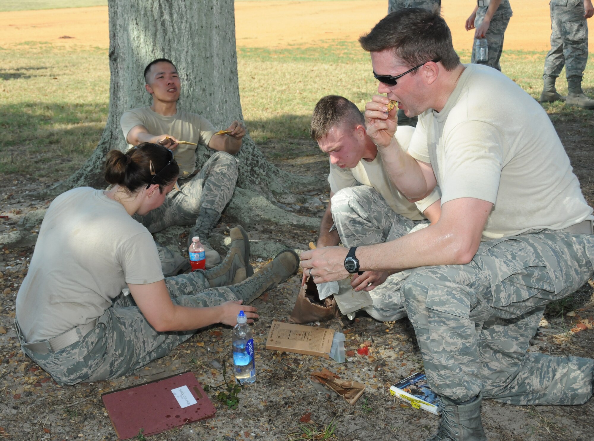 Shock and Awe team members, 1st Lt. Aftan Boudreaux, Airman First Class Xeng Xiong, Staff Sgt. David Cannon and Capt. Rob Bouchillon, 81st Force Support Squadron, divide a Meal Ready to Eat package in which they must consume the entire meal as part of the challenge, “brown bag lunch,” before moving on to the next challenge during the 81st Mission Support Group Ultimate Warrior Challenge June 1, 2012, at the Triangle Track at Keesler Air Force Base, Miss.  The challenge was held in honor of fellow service members who lost their lives in the fight for our nation’s freedom. It consisted of nine four-member teams racing in a competition designed to take them through various aspects of a deployment.  (U.S. Air Force photo by Kemberly Groue)