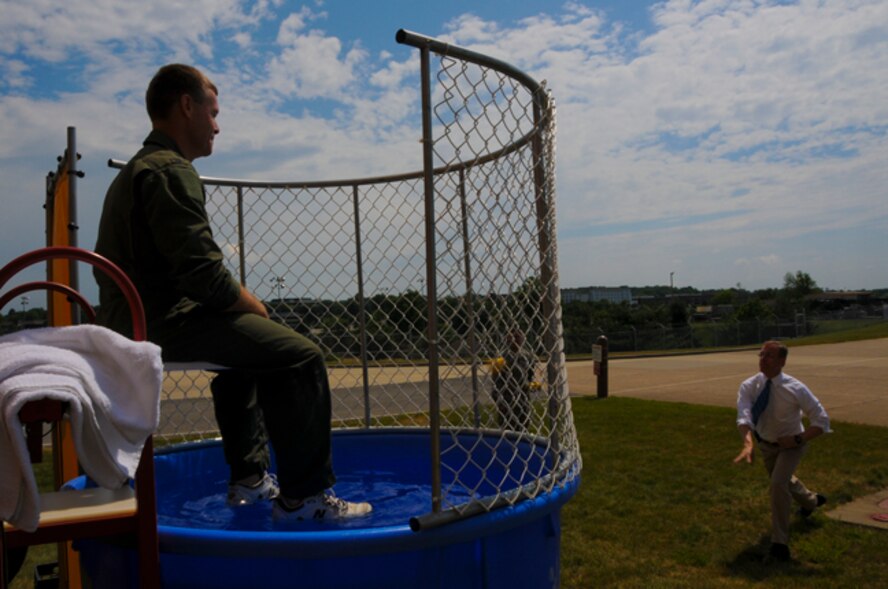 Col. Craig C. Peters, 911th Airlift Wing commander, sits in the dunk tank while Rep. Tim Murphy, R-PA 18, throws the first pitch at the 911 AW Family Day, June 3, 2012. Colonel Peters was the first of many members of senior leadership to sit in the dunk tank as a morale boost for the troops. (U.S. Air Force photo by Senior Airman Joshua J. Seybert/Released)