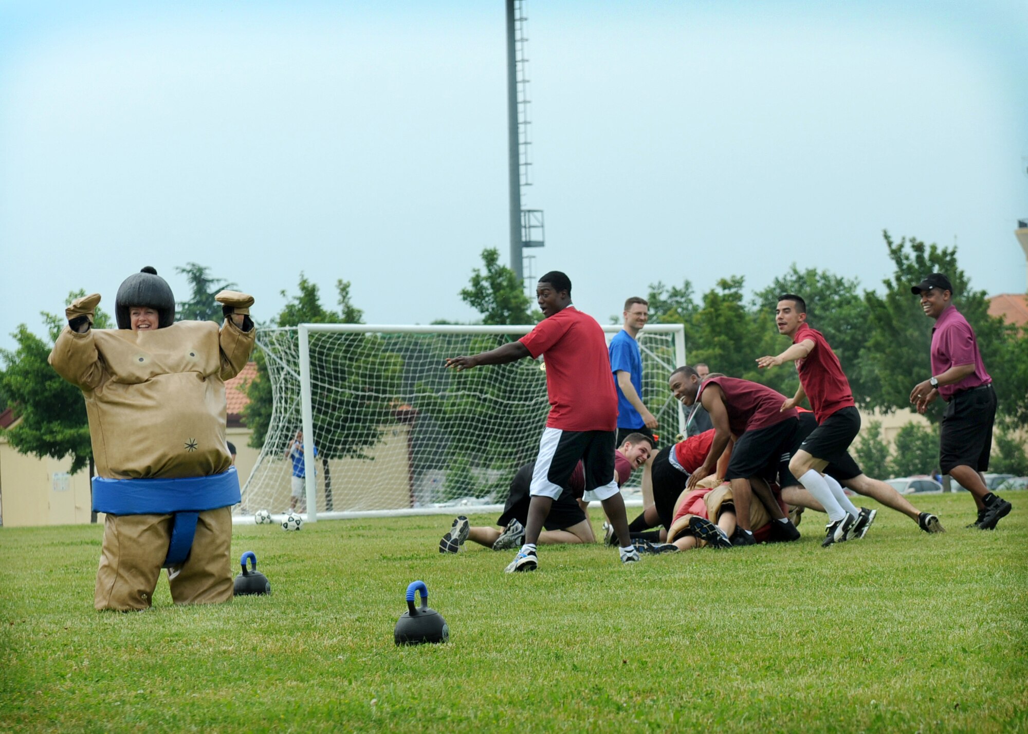 Members of the 31st Medical Group tackle Chief Master Sgt. William Cisna while his opponent, Col. Linda Lawrence, celebrates her victory during a sumo wrestling event at the 31st Fighter Wing sports day tournament June 1 at the Dragon Fitness Center. Hosted by the 31st Force Support Squadron and assisted by 66 base volunteers, the all-day event was put together to give the wing a chance to unwind and engage with each other through various physical fitness activities. Lawrence is the 31st MDG commander, while Cisna is the group superintendent. (U.S. Air Force photo/Senior Airman Katherine Windish)