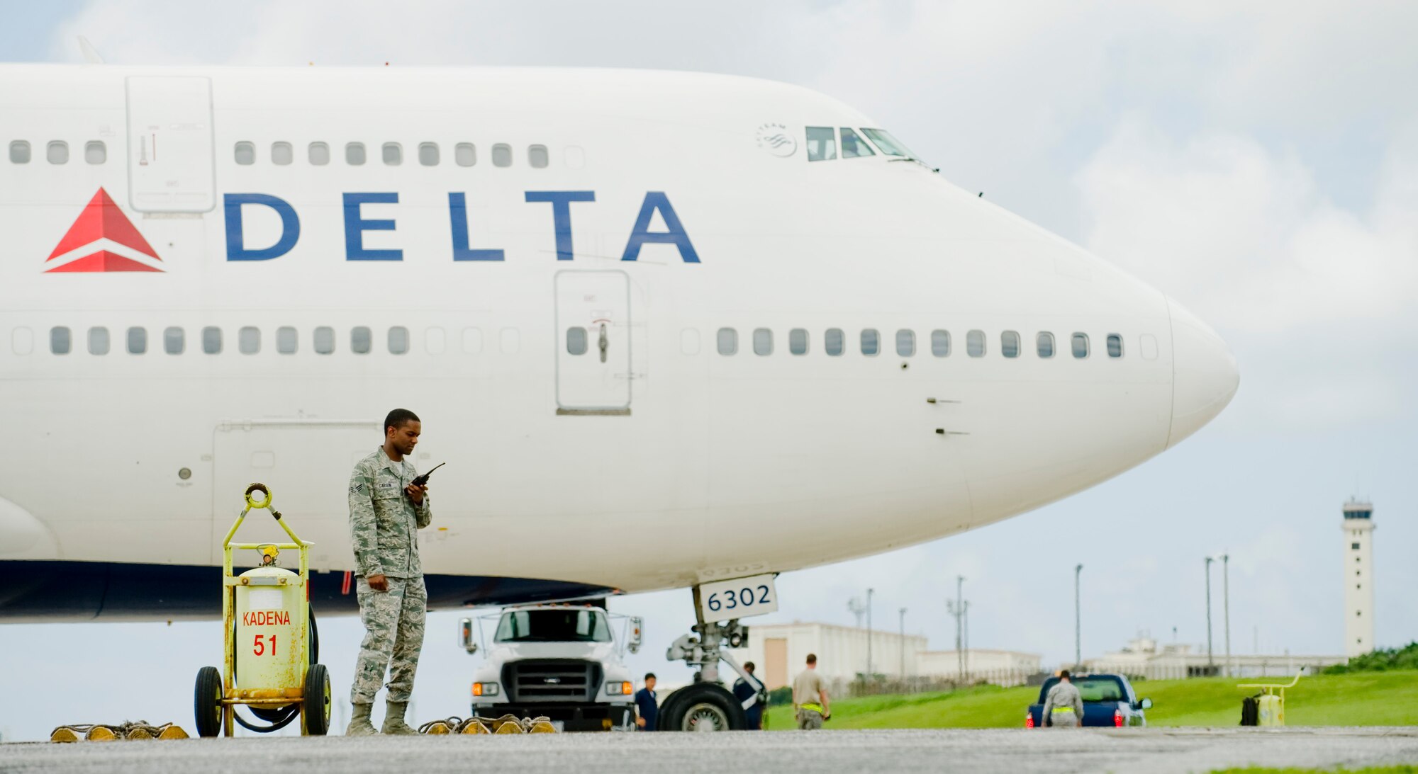 Senior Airman James Carson, 18th Operations Support Squadron airfield manager, ensures agencies respond to a Boeing 747 parked on the flight line of Kadena Air Base, Japan, June 6, 2012. Airmen from the 18th OSS, 733rd Air Mobility Squadron and 18th Operations Group assisted the aircraft after it experienced an in-flight medical emergency. The units provided maintenance, refueling and other ground support services. Last month, Kadena Airmen assisted two civilian aircraft originally bound for Naha. Kadena Air Base is a divert location for Naha airfield and is occasionally used when weather or other situations prevent aircraft from landing at Naha. (U.S. Air Force Photo/Staff Sgt. Jonathan Steffen)