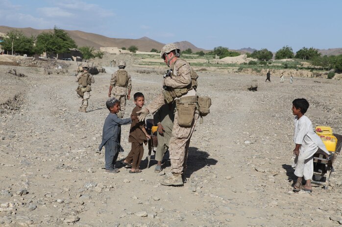 Petty Officer 3rd Class Matthew Sears, a corpsman with C Company, 1st Battalion, 8th Marines, Regimental Combat Team 6 shakes hands with children who run up to him while patrolling through the Gostan valley, Nimruz province, Afghanistan. Before joining the Navy, Sears was a firefighter/EMT in his hometown of Dayton, Ohio.