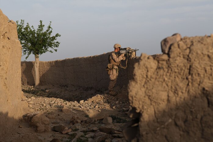 Lance Cpl. Frank Young, squad automatic weapon gunner, Charlie Company, 1st Battalion, 8th Marine Regiment, provides security for the rest of the Marines in his squad as they prepare to clear a compound from enemy forces, April 17, 2012. The Marines and sailors with Charlie Company took part in a month long operation where they cleared the Gostan valley of enemy forces.