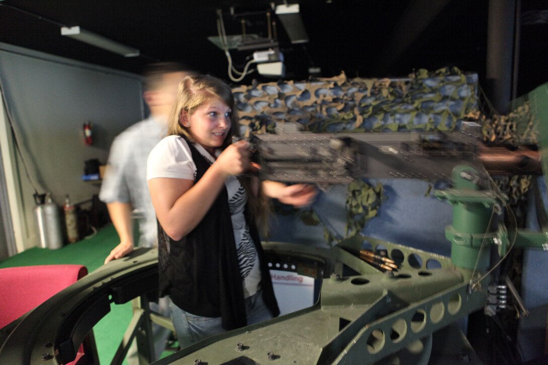 A girl from Wilderness Way Girls Camp handles a large weapon at an Indoor Simulated Marksmanship Trainer aboard Marine Corps Base Camp Lejeune, June 1. The girl was there for a fieldtrip and was able to handle a wide variety of weapons. 