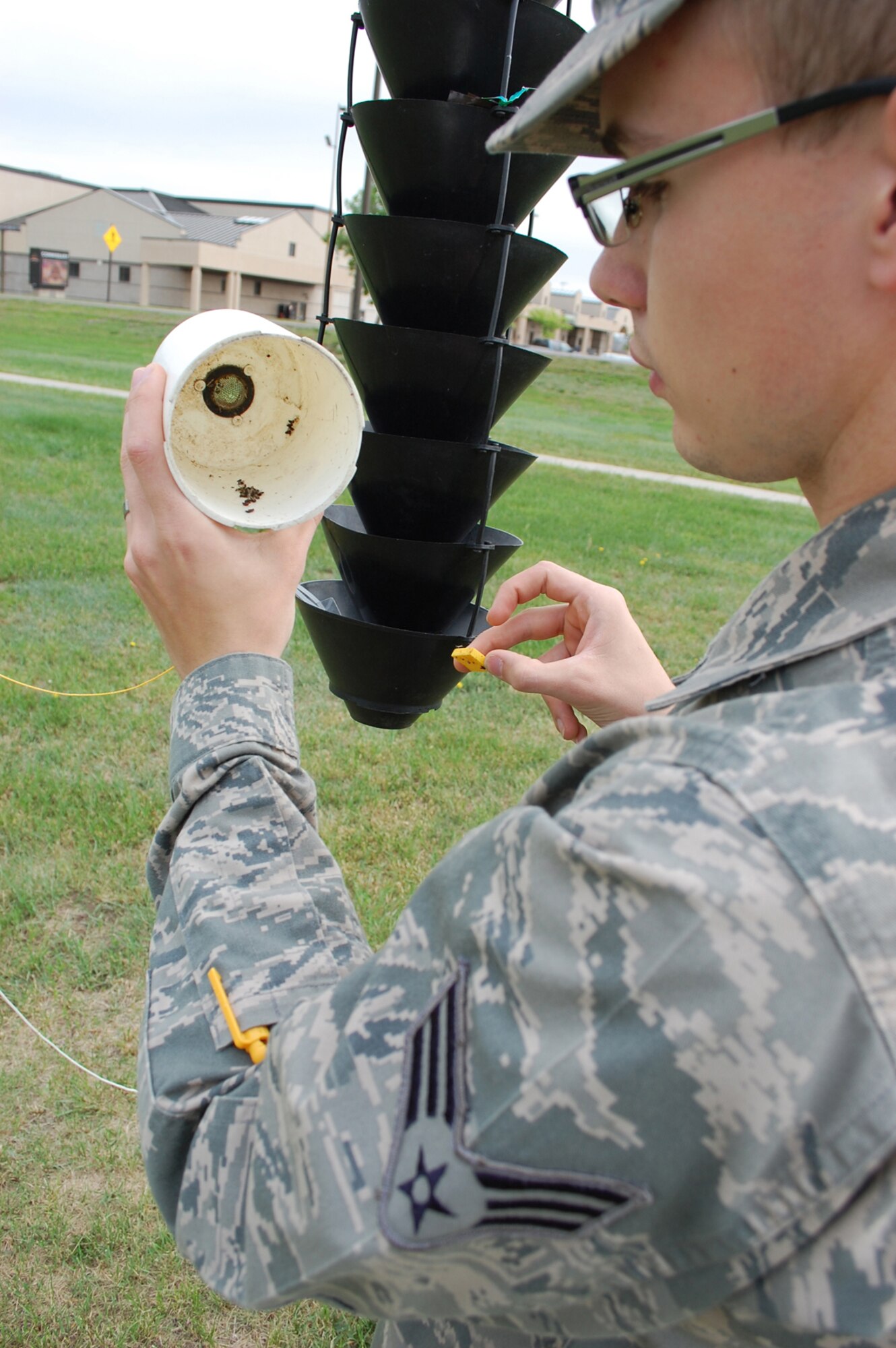 Biehn checks the contents of one of the beetle traps on base June 5. Once the beetles are trapped in the device, the collections are sent to the U.S. Forest Service to help categorize the species of beetles on the installation. (U.S. Air Force photo/Senior Airman Kristina Overton)