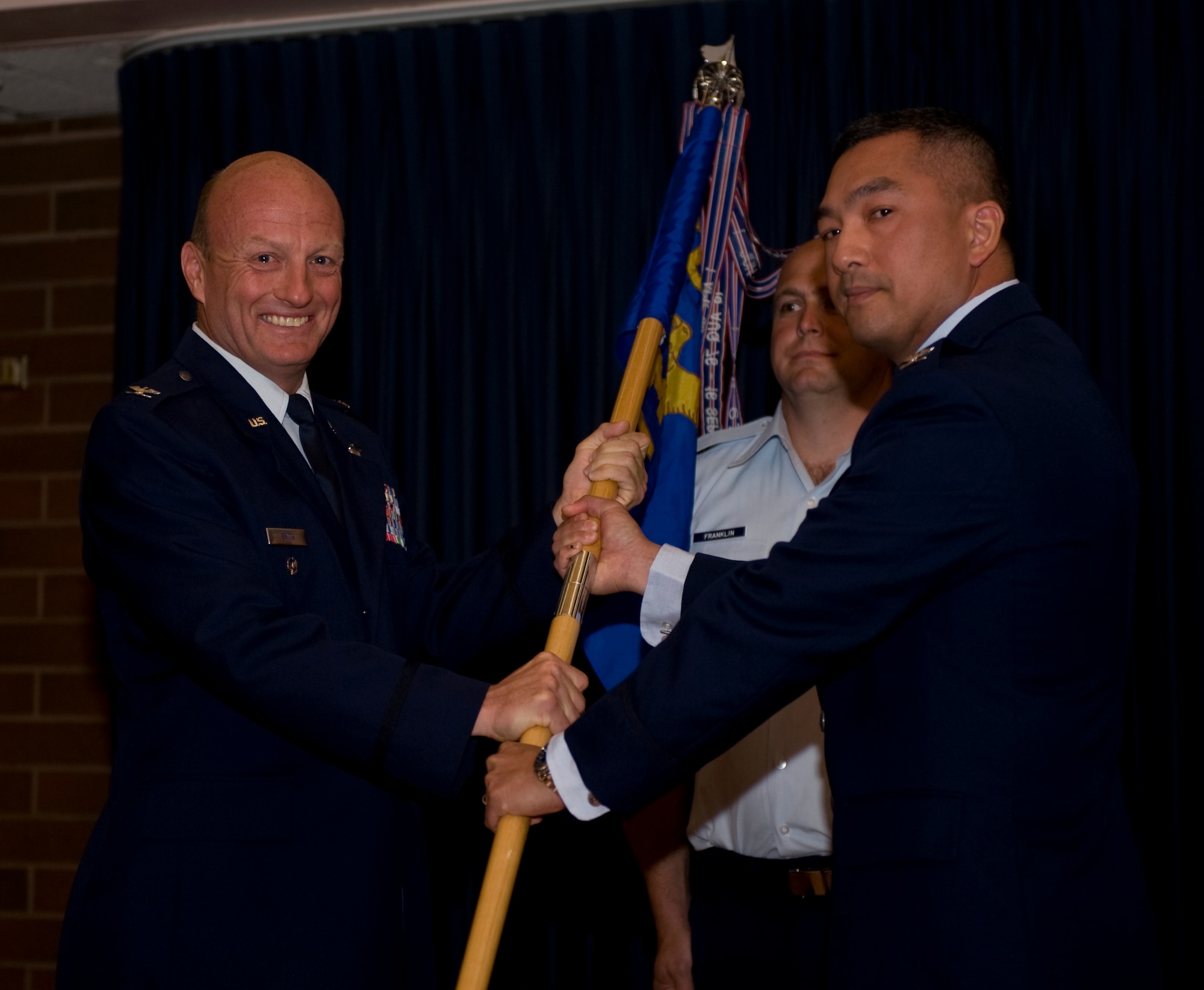 U.S. Air Force Col. Sarady Tan receives the 366th Medical Group guidon from Col. Bruce M. Smith, 366th Fighter Wing vice commander, May 22, 2012, at Mountain Home Air Force Base, Idaho. Tan, who is coming from Scott AFB, Ill., has been in the Air Force for more than 17 years and flown in 15 different aircraft with more than 1,500 flight hours logged. (U.S. Air Force photo/Airman 1st Class Jonathan Glanville)