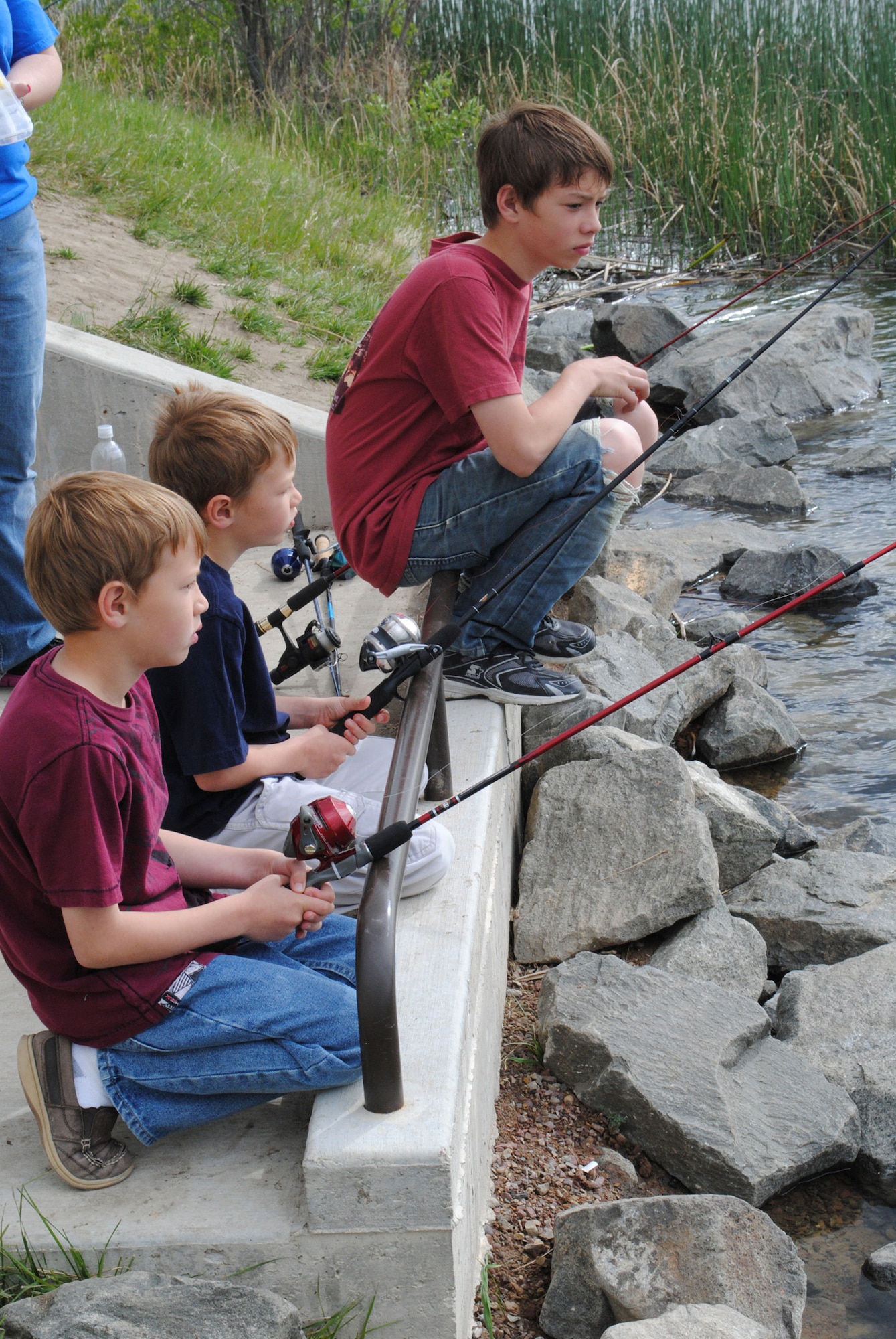 From left, Aden, 7; Ashton, 7; and Bryer, 12, patiently wait to catch a fish. There were more than 300 rainbow trout stocked in Powow Pond recently, making a fish almost inevitable for children. (U.S. Air Force photo/Airman 1st Class Cortney Paxton)