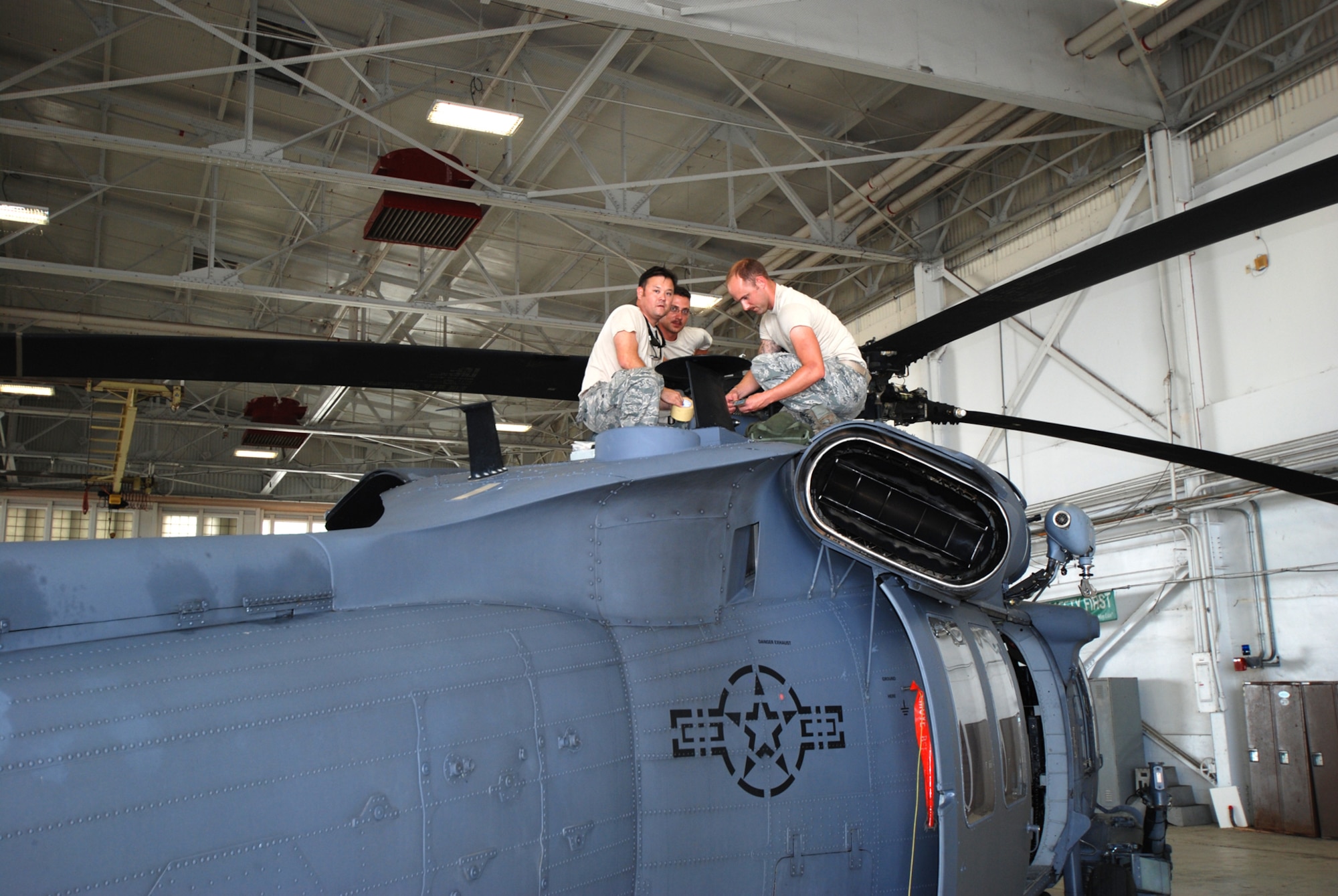Maintenance Airmen from the 920th Rescue Wing, Patrick Air Force Base, Fla., perform routine maintenance next to the rotor system of this HH-60G Pave Hawk helicopter June 7. The wing's mission is combat search and rescue. (U.S. Air Force photo/Capt. Cathleen Snow)
