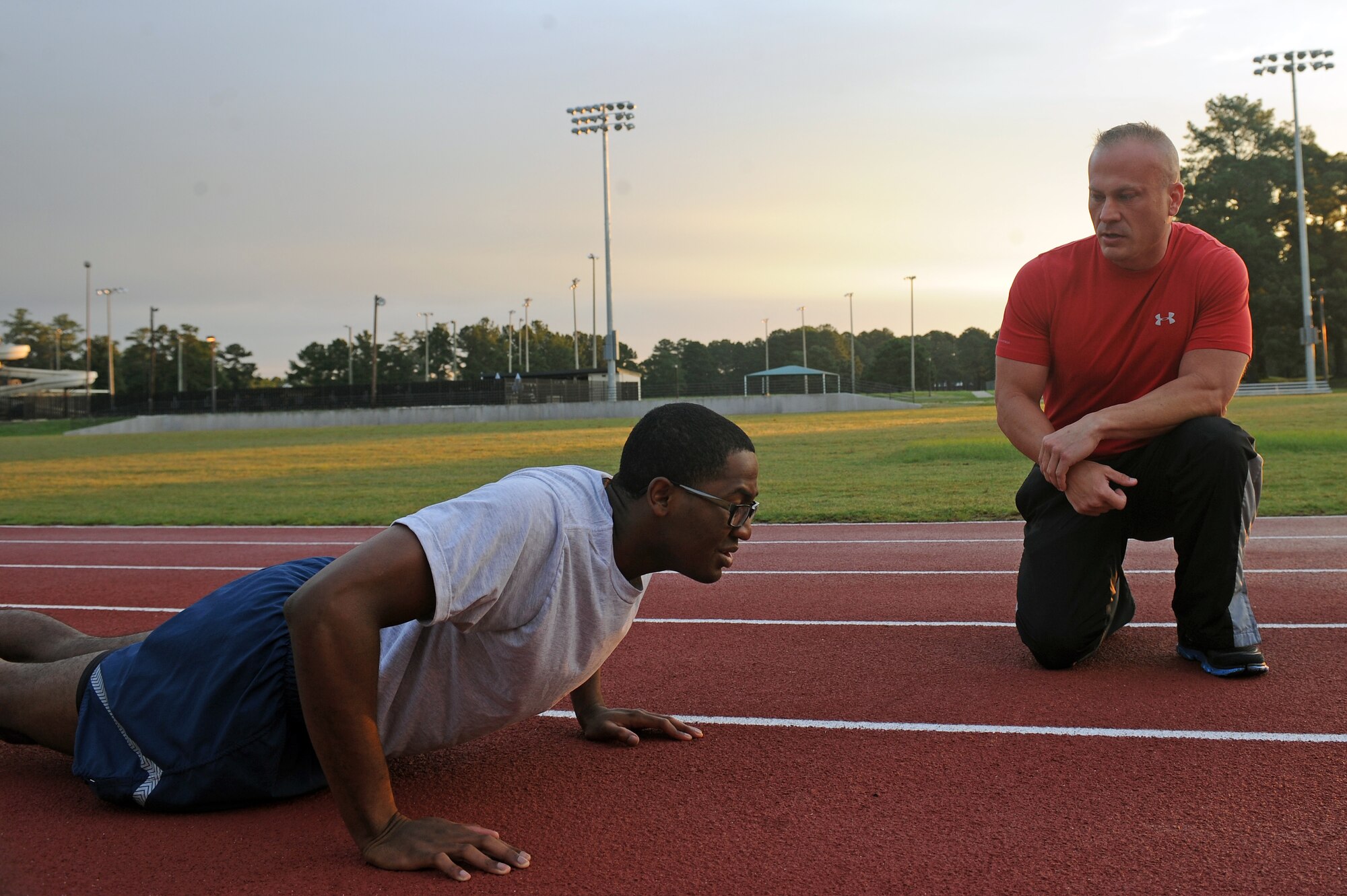 Mike Unden motivates Airman 1st Class Gabriel Stephens as he performs push-ups during the wing Fitness Improvement Training class on Seymour Johnson Air Force Base, N.C., June 6, 2012. The class utilizes high intensity interval training to get Airmen into shape for their physical fitness tests. Unden, 4th Force Support Squadron military fitness specialist, is from Wichita, Kan. Stephens, 4th Logistics Readiness Squadron material management journeyman, is a native of Savannah, Ga. (U.S. Air Force photo/Airman 1st Class John Nieves Camacho/Released) 