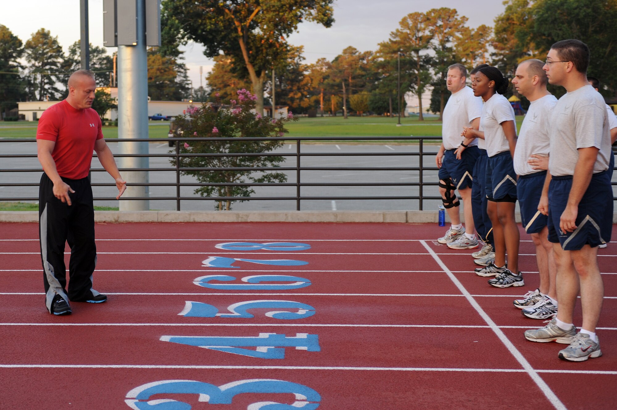 Mike Unden instructs Airmen participating in the wing Fitness Improvement Training program at the quarter-mile track on Seymour Johnson Air Force Base, N.C., June 6, 2012. The program is conducted Monday, Wednesday and Friday starting at 5:50 a.m. and lasts 45 minutes. Unden, 4th Force Support Squadron military fitness specialist, is from Wichita, Kan. (U.S. Air Force photo/Airman 1st Class John Nieves Camacho/Released)