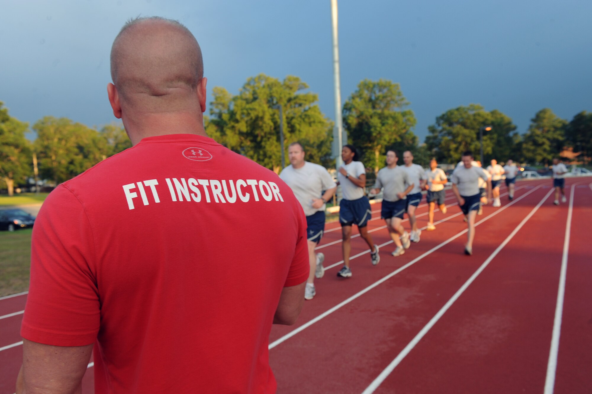 Mike Unden watches as Airmen complete last man up exercise during the wing Fitness Improvement Training program at the quarter-mile track on Seymour Johnson Air Force Base, N.C., June 6, 2012. This exercise uses sprinting to build stamina and decrease run times. Unden, 4th Force Support Squadron military fitness specialist, is from Wichita, Kan. (U.S. Air Force photo/Airman 1st Class John Nieves Camacho/Released)