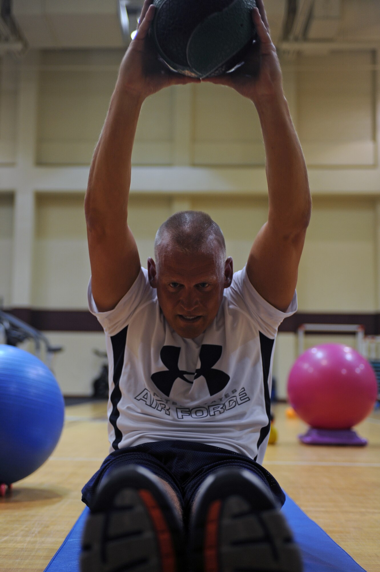 U.S. Air Force Senior Master Sgt. Bob Ewest performs sit-ups with a medicine ball during the abdominal and core workout class in the fitness center on Seymour Johnson Air Force Base, N.C., June 6, 2012. Class members use medicine balls, dumbbells and kettle bells during the class to intensify their training. Ewest, 916th Aircraft Maintenance Squadron development training flight NCO in charge, is a native of Milwaukee. (U.S. Air Force photo/Airman 1st Class John Nieves Camacho/Released)