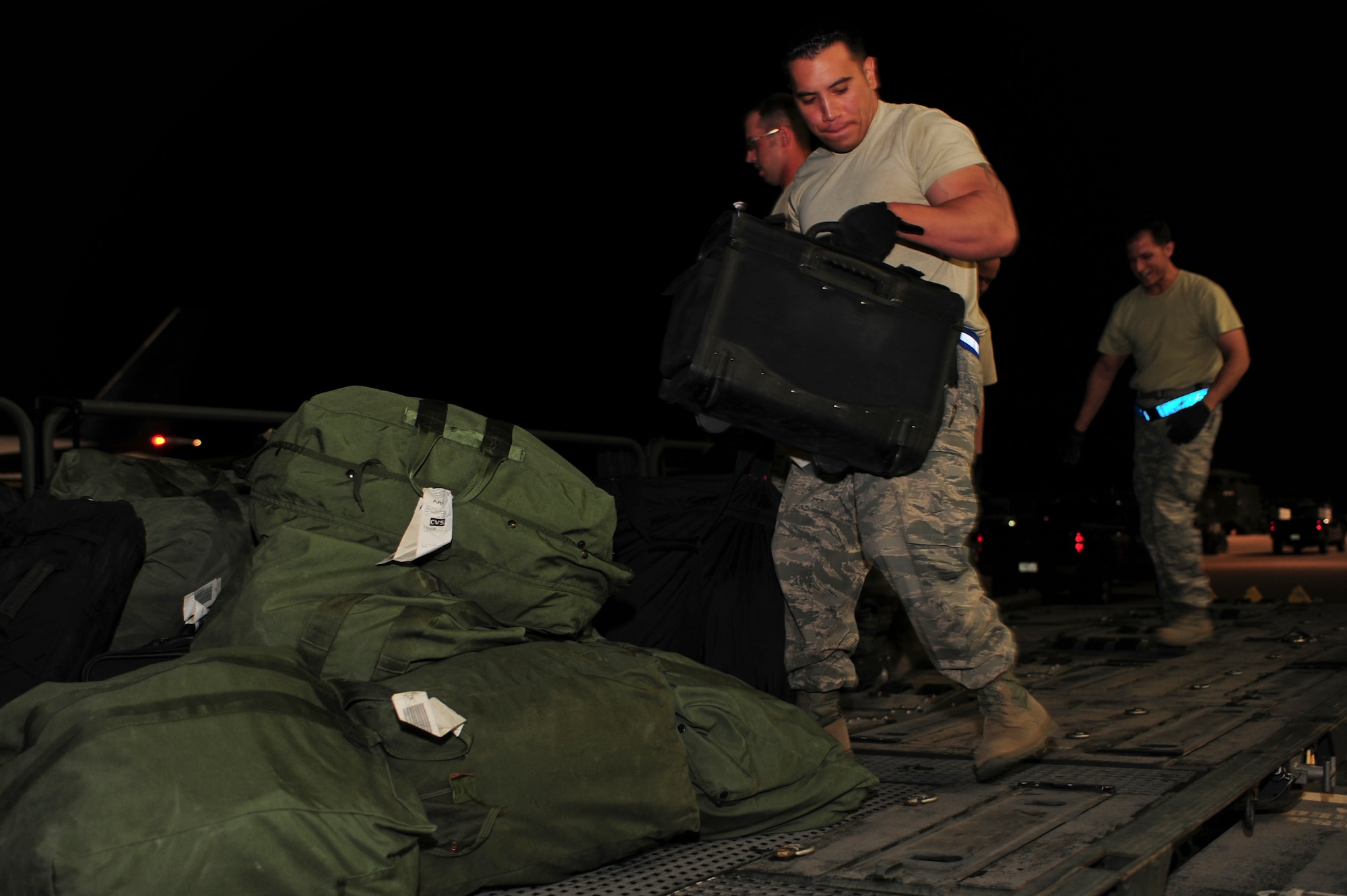 Airmen remove luggage and mobility bags from an aircraft during Operation Homecoming at Cannon Air Force Base, N.M., June 4, 2012. Operation Homecoming is a monthly event held to welcome Air Commandos back from worldwide deployments and reunite them with family and friends. (U.S. Air Force photo by Airman 1st Class Eboni Reece)