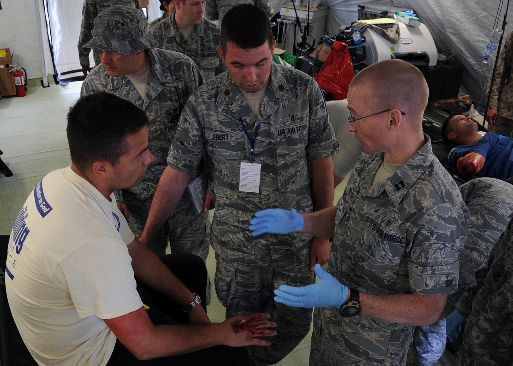 U.S. Air Force Capt. Brian Davis, right, and Maj. Andy Ebert, middle, discuss a patient's injury during Shared Resilience 2012 at Capljina, Bosnia-Herzegovina, June 5, 2012. The goals of the exercise are to strengthen interoperability, facilitate training in crisis response and disaster management, and validate the readiness of deployable military medical and humanitarian assistance teams. Davis and Ebert are both from Royal Air Force Lakenheath, England. (U.S. Air Force photo/Staff Sgt. Daryl Knee)