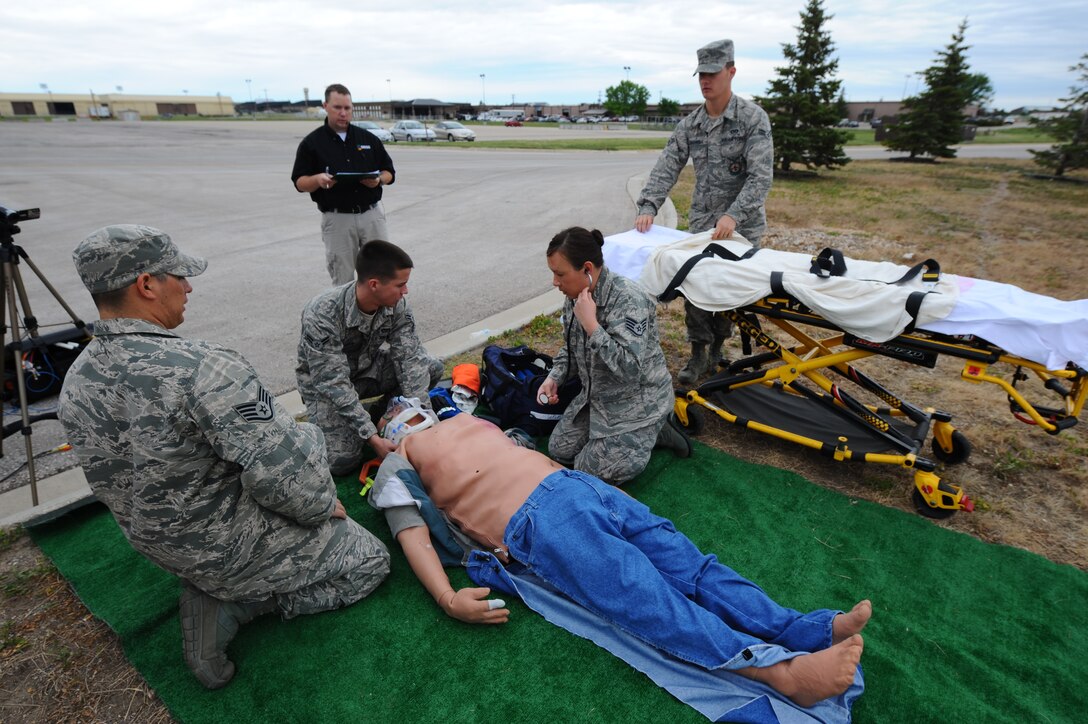 Airmen from the 28th Civil Engineer Squadron fire department and 28th Medical Group provide emergency response actions using a human patient simulator during a training exercise at Ellsworth Air Force Base, S.D., May 23, 2012. After the scenarios, Airmen were debriefed on their performance and given tips to more effectively handle victims in emergency situations. (U.S. Air Force photo by Airman 1st Class Zachary Hada/Released)