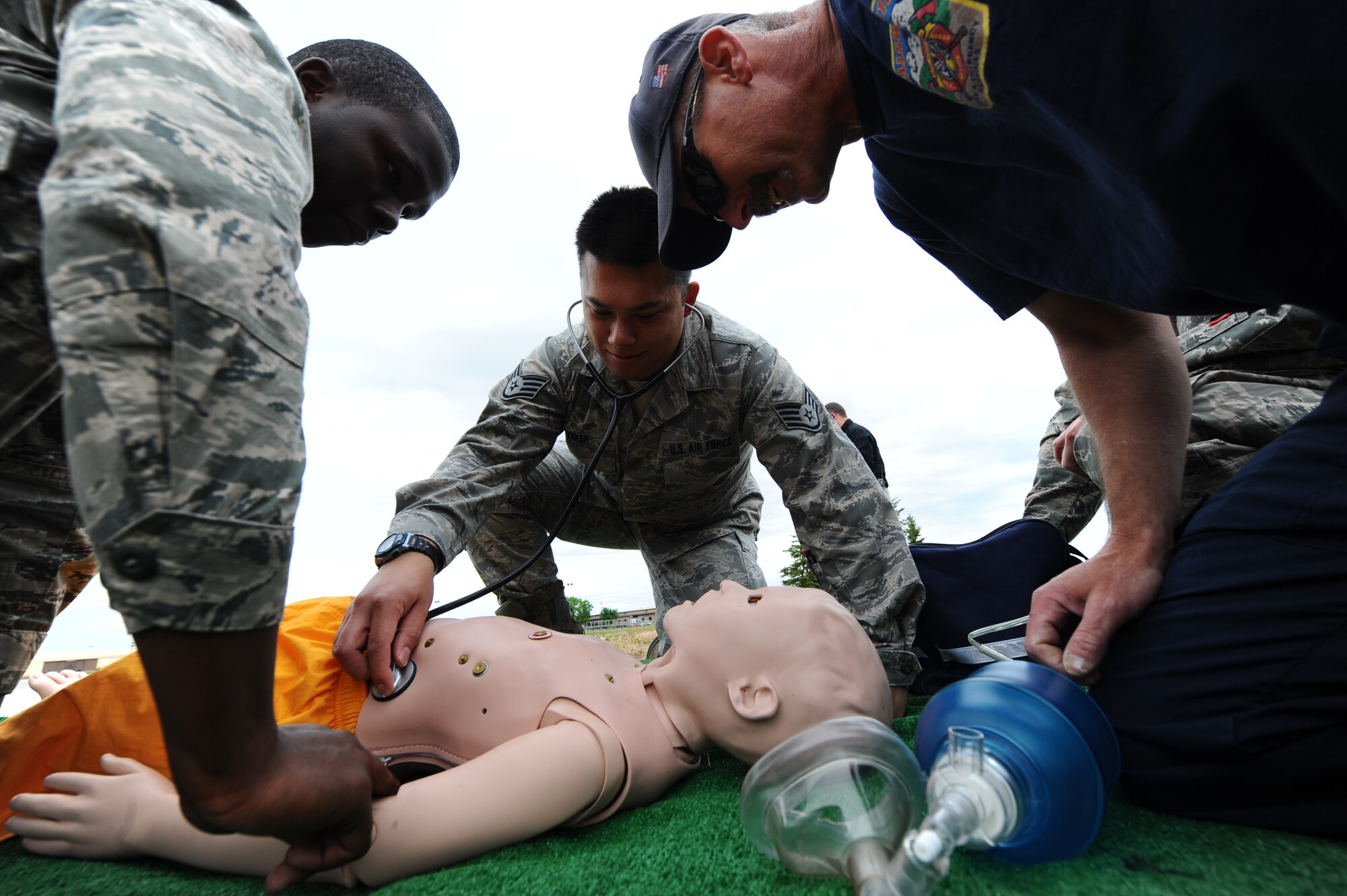 Staff Sgt. Clayton Lurker, 28th Medical Group medical technician, checks for vital signs on a simulated patient with the assistance of Airman 1st Class Irving Adams, 28th Civil Engineer Squadron fire protection apprentice, and Bill Cina, 28th CES civilian contractor, during joint trauma medical training at Ellsworth Air Force Base, S.D., May 23, 2012. Ellsworth Airmen received both lectures and hands-on learning scenarios provided by Simulation in Motion-South Dakota, a program dedicated to implementing statewide outreach education for hospital personnel and first responders. (U.S. Air Force photo by Airman 1st Class Zachary Hada/Released)