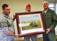 From left, Col. David Pavey, 927th Air Refueling Wing commander, and retired Air Force Capt. Norm Bild present Col. Andy Comtois, 919th Special Operations Wing commander, with a signed lithograph from artist Keith Woodcock at MacDill Air Force Base, Fla., recently.   The artwork, titled “Rescue on the Plain of Jars” commemorates U.S.-led covert military operations in Laos during the Vietnam War.  Knowing the 919th SOW’s covert operations mission, Pavey and Bild, an amateur historian, were inspired to donate the historical artwork during the Duke Field unit’s civic leader tour of MacDill and its 927th ARW headquarters. (U.S. Air Force photo/Tech. Sgt. Jasmin Taylor)