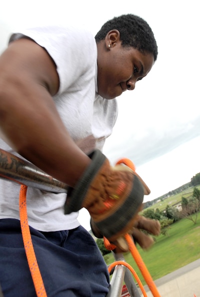 U.S. Air Force Senior Airman Denae Calmes pulls a rope at the burn tower as she practices for a firefighter combat challenge on Seymour Johnson Air Force Base, N.C., June 5, 2012. During the challenge in mid-August, Calmes will have to hoist a 42-pound fire hose attached to a rope. Calmes, 4th Civil Engineer Squadron firefighter, hails from High Point, N.C. (U.S. Air Force photo/Airman 1st Class Aubrey Robinson/Released)