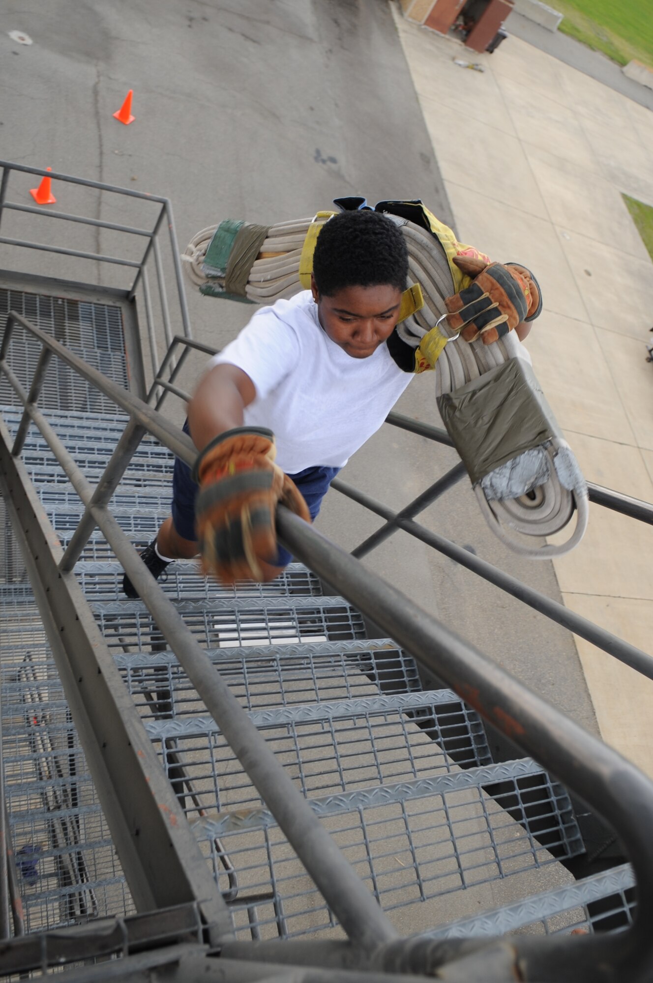 U.S. Air Force Senior Airman Denae Calmes carries a high rise pack up a staircase at the burn tower in preparation for a firefighter combat challenge on Seymour Johnson Air Force Base, N.C., June 5, 2012. During the challenge firefighters worldwide will compete in five firefighting tasks during a timed competition. Calmes, 4th Civil Engineer Squadron firefighter, hails from High Point, N.C. (U.S. Air Force photo/Airman 1st Class Aubrey Robinson/Released)