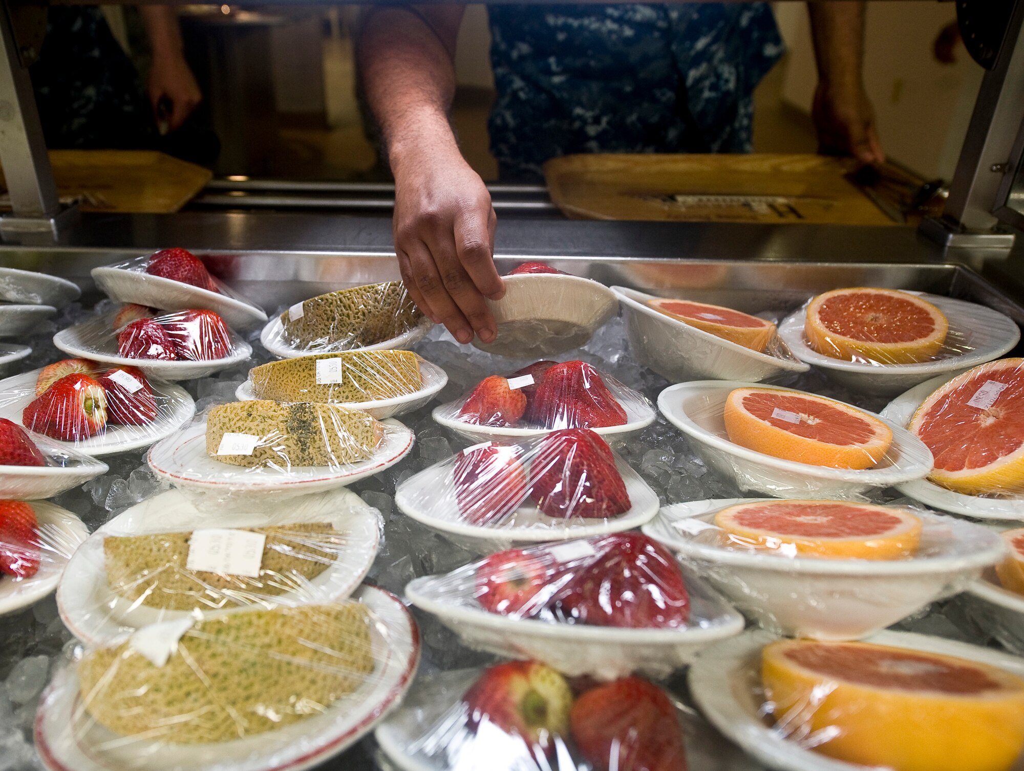 A patron takes a plate of strawberries from the serving line in the Red River Dining Facility on Barksdale Air Force Base, La., June 6. Fruit is one of the healthy food options the dining facility provides for it's customers. (U.S. Air Force photo/Staff Sgt. Chad Warren)(RELEASED)