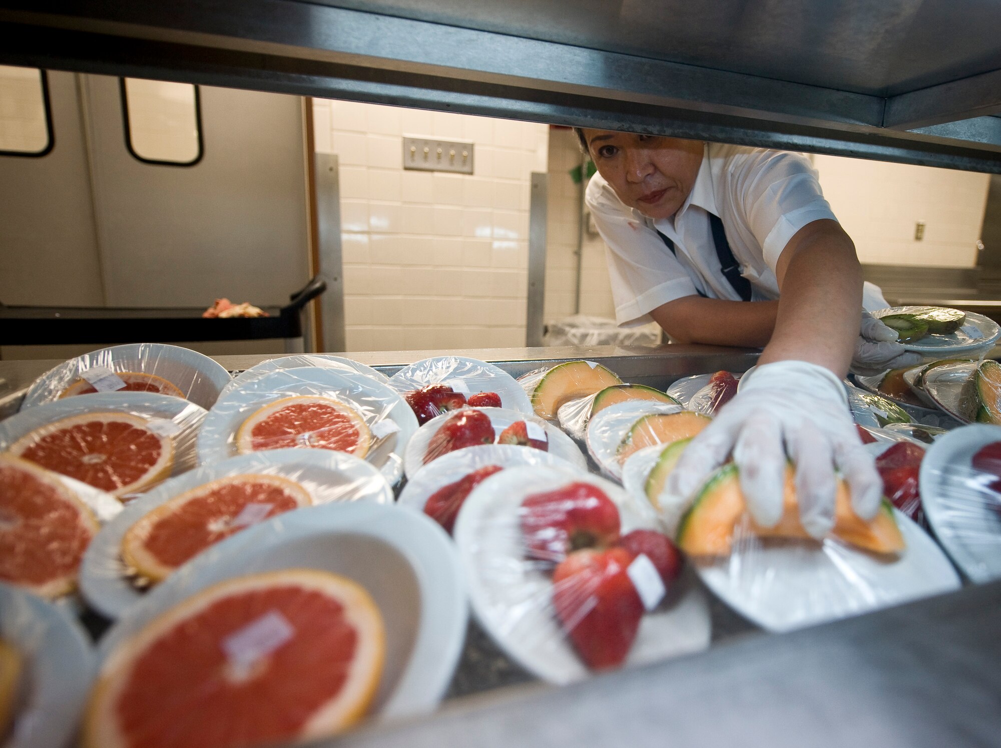 Song Su McNeese, 2nd Force Support Squadron, places fruit on the serving line in the Red River Dining Facility on Barksdale Air Force Base, La., June 6. Keeping a variety of fruit on the line gives patrons the option to add healthy side items to their meals. (U.S. Air Force photo/Staff Sgt. Chad Warren)(RELEASED)