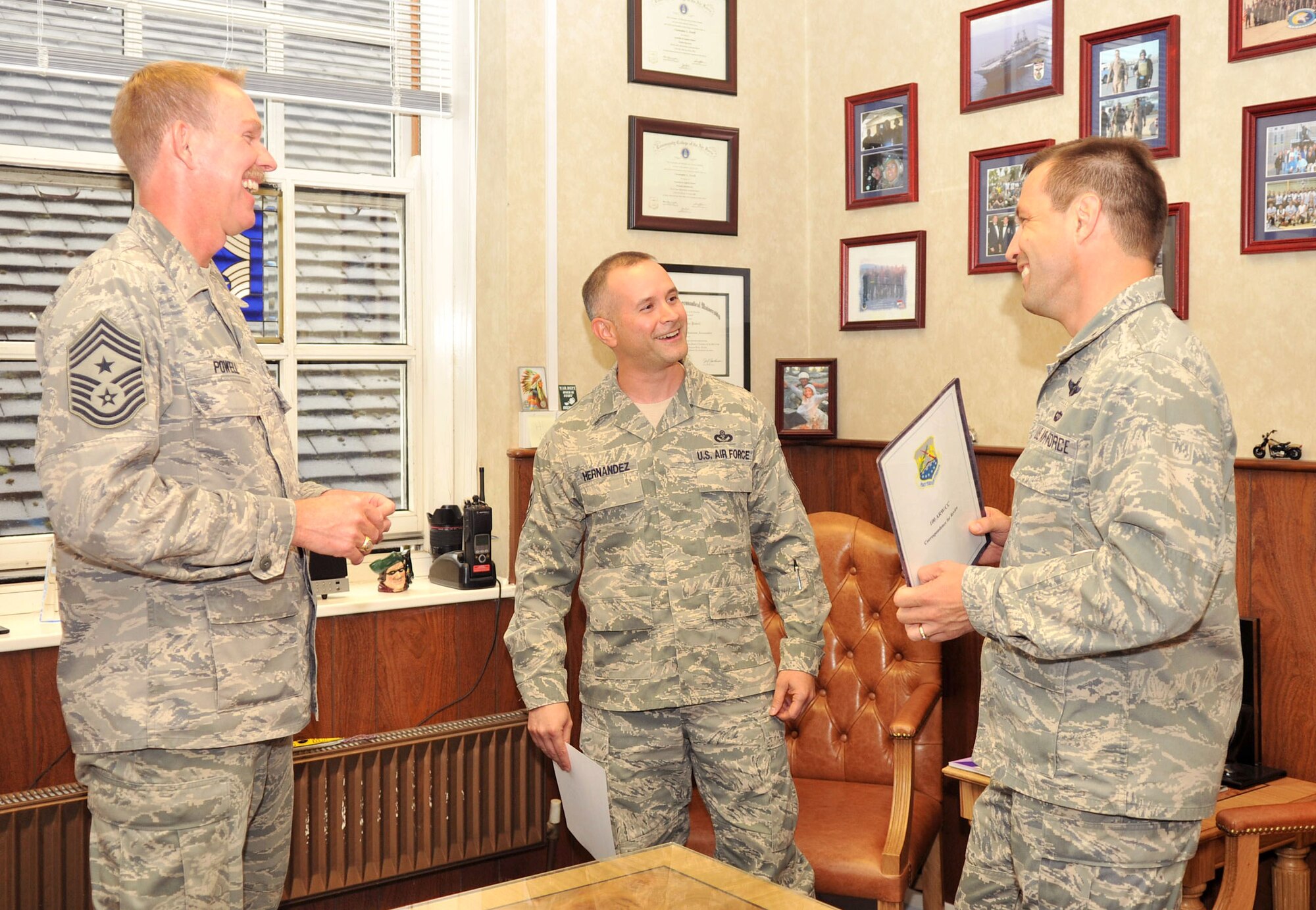 RAF MILDENHALL, England – Senior Master Sgt. Emilio Hernandez, center, 100th Civil Engineer Squadron, reacts to the news of being named one of the Air Force’s 12 Outstanding Airmen of the Year here June 7, 2012. Col. Christopher Kulas, 100th Air Refueling Wing commander, and Chief Master Sgt. Christopher Powell, 100th ARW Command Chief Master Sgt., presented Hernandez with a certificate congratulating him on his achievement. (U.S. Air Force photo/Senior Airman Jerilyn Quintanilla) 