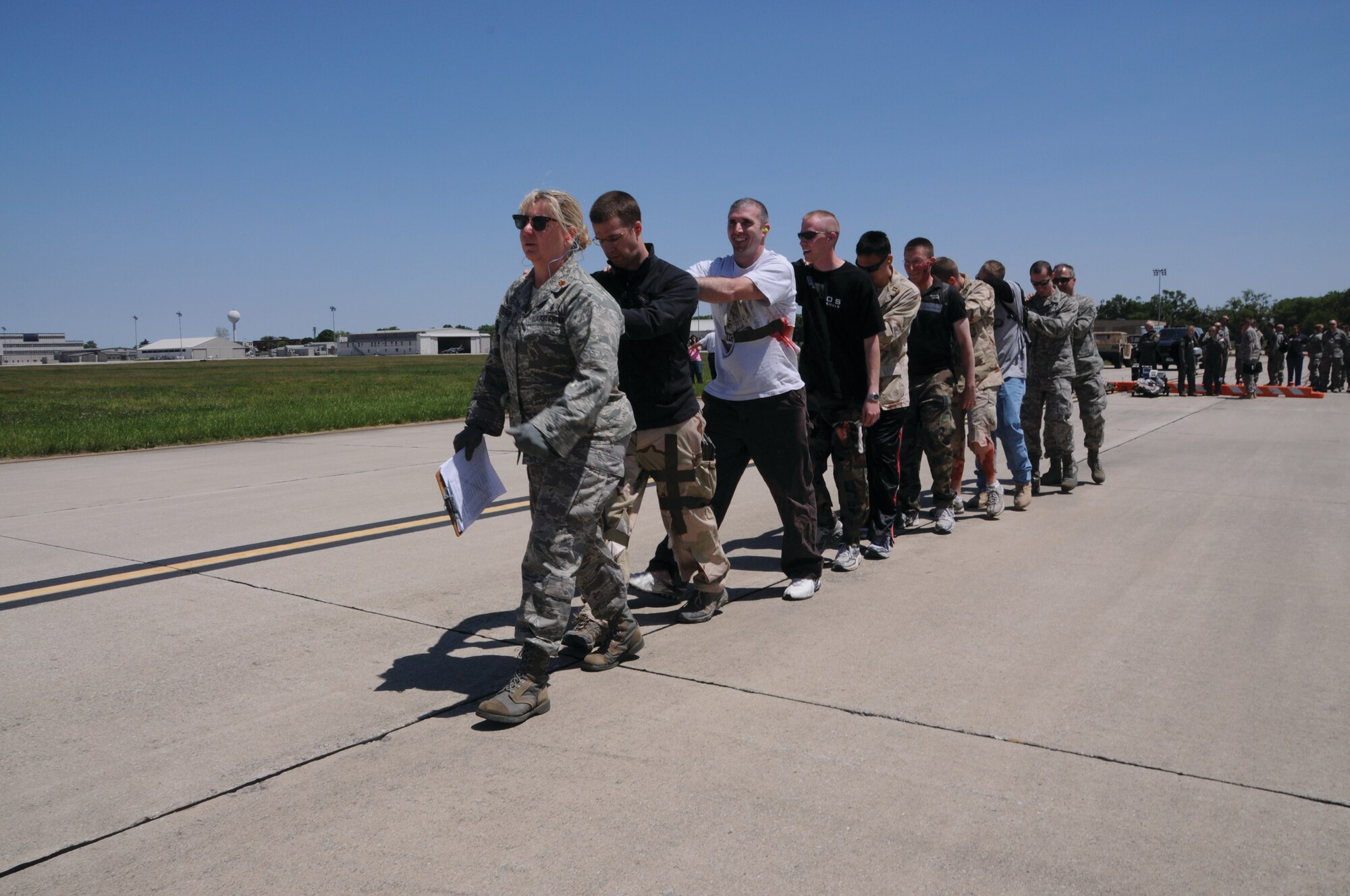 WRIGHT-PATTERSON AIR FORCE BASE, Ohio - Maj. Karen Keller, 445th Aeromedical Staging Squadron, leads a group of “patients” on board a 445th Airlift Wing C-17 Globemaster III May 17. Mock patients were shuttled in stretchers under the medical care of ASTS to the preassembled patient stations onboard the C-17. The scenario was part of an overall mass casualty exercise that included participants from Wright State, Ohio State Highway Patrol, Fairborn Fire Department, and the Army National Guard. (U.S. Air Force photo/Tech. Sgt. Anthony Springer)