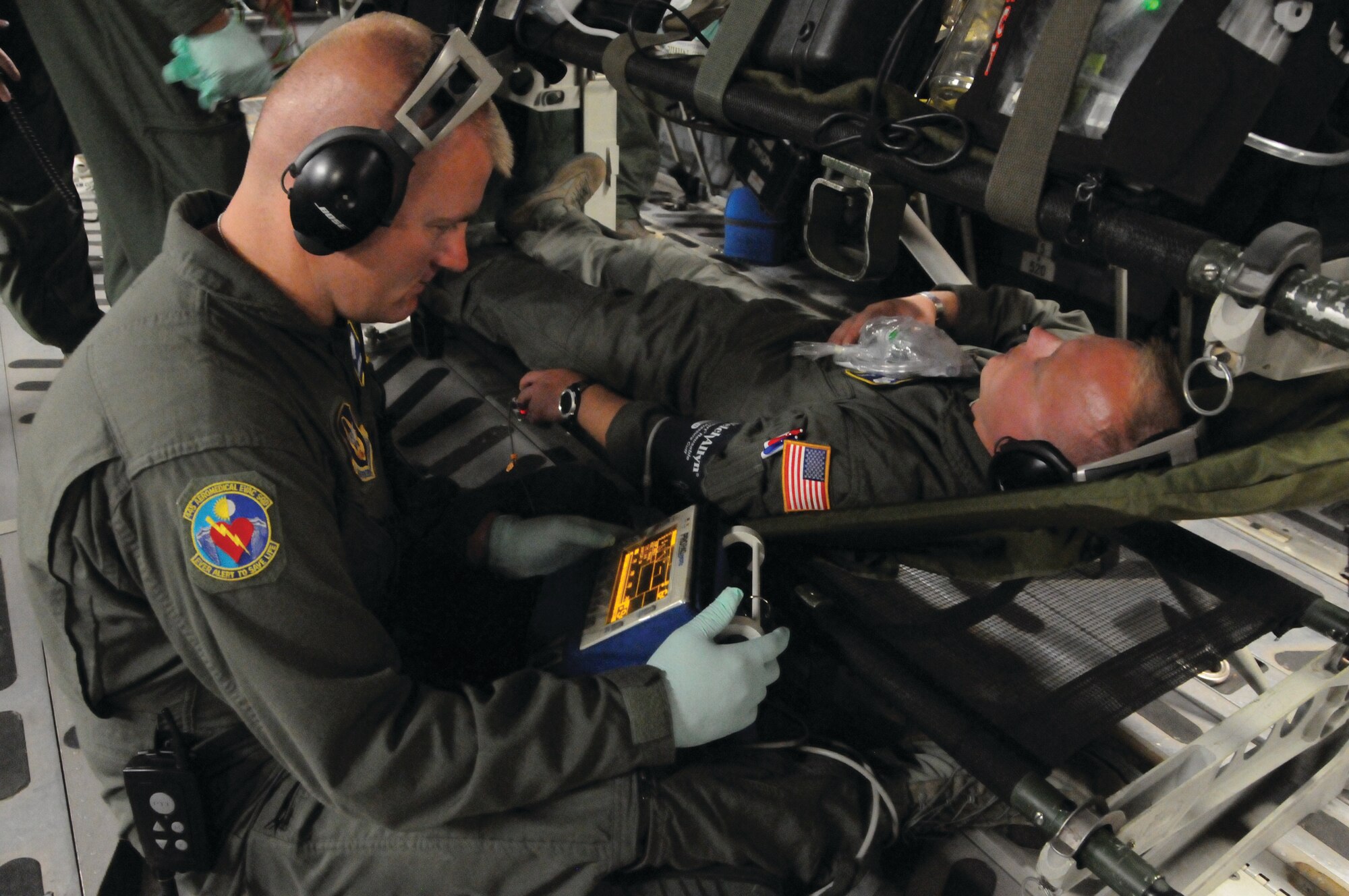 WRIGHT-PATTERSON AIR FORCE BASE, Ohio - Master Sgt. Frederick Hageman, III, monitors the vital signs of mock patient Tech. Sgt. Michael Flaata, during a routine training mission that was part of the conclusion of a joint mass casualty training exercise May 17. Both are from the 445th Aeromedical Evacuation Squadron. The mass casualty exercise included participants from Wright State, Ohio State Highway Patrol, Fairborn Fire Department, and the Army National Guard. (U.S. Air Force photo/Tech. Sgt. Anthony Springer)