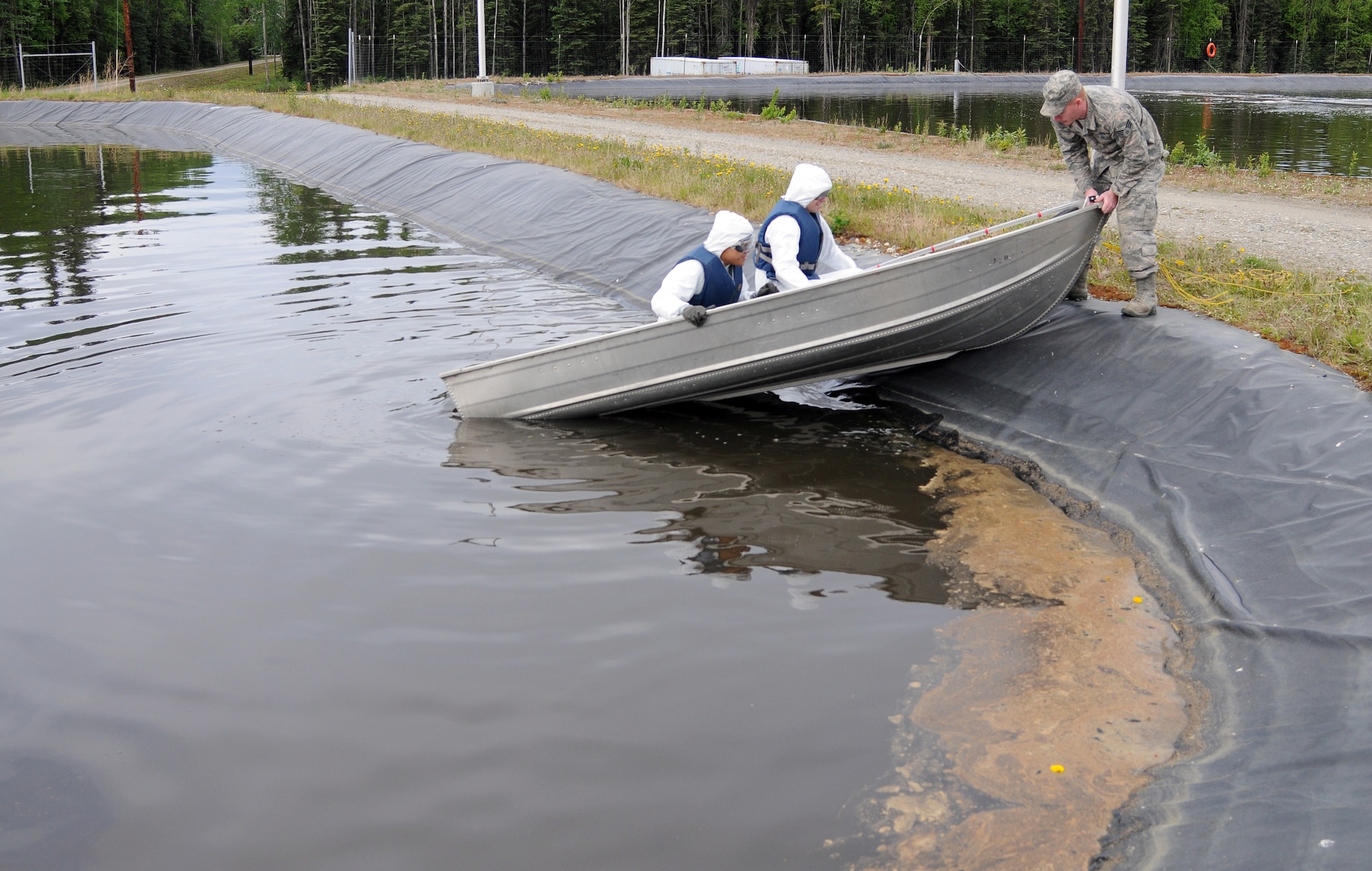 U.S. Air Force Senior Airman Joseph Lagrow, 354th Civil Engineer Squadron waste water treatment plant operator, lowers a boat into a waste water lagoon June 1, 2012, Eielson Air Force Base, Alaska. During the summer, operators go by boat into the lagoon to perform semi-annual checks on equipment. (U.S. Air Force photo/Senior Airman Janine Thibault)