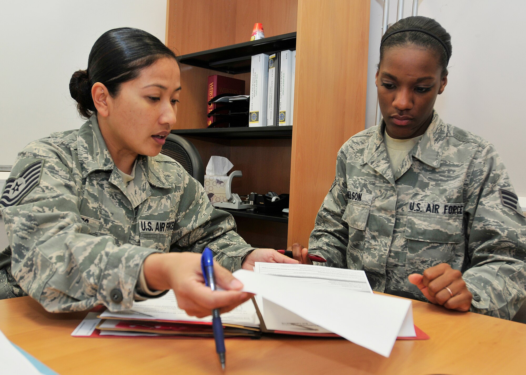 ROYAL AIR FORCE LAKENHEATH, England – Tech. Sgt. Ann Michelle Urdiales, 48th Communications Squadron unit deployment manager, discusses deployment information with Senior Airman Ashley Nelson, 48th CS asset management technician, in the 48th CS building June 7, 2012. Urdiales was nominated for a Liberty Spotlight because she displays the core value of "Excellence in All We Do.” (U.S. Air Force photo by Senior Airman Tiffany M. Deuel)