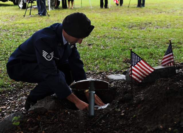 Staff Sgt. Brandon Edwards, 628th Security Forces dog handler, lays Waldo to rest at Joint Base Charleston - Air Base, S.C.  June 6, 2012. Waldo, a military working dog, was assigned to the 628th Security Forces Squadron and served most of his career here. He was deployed twice to Afghanistan. During his career, Waldo conducted 2,304 hours of searches and completed 425 hours of detection training, leading to safer communities. (U.S. Air Force photo/Airman 1st Class Ashlee Galloway)