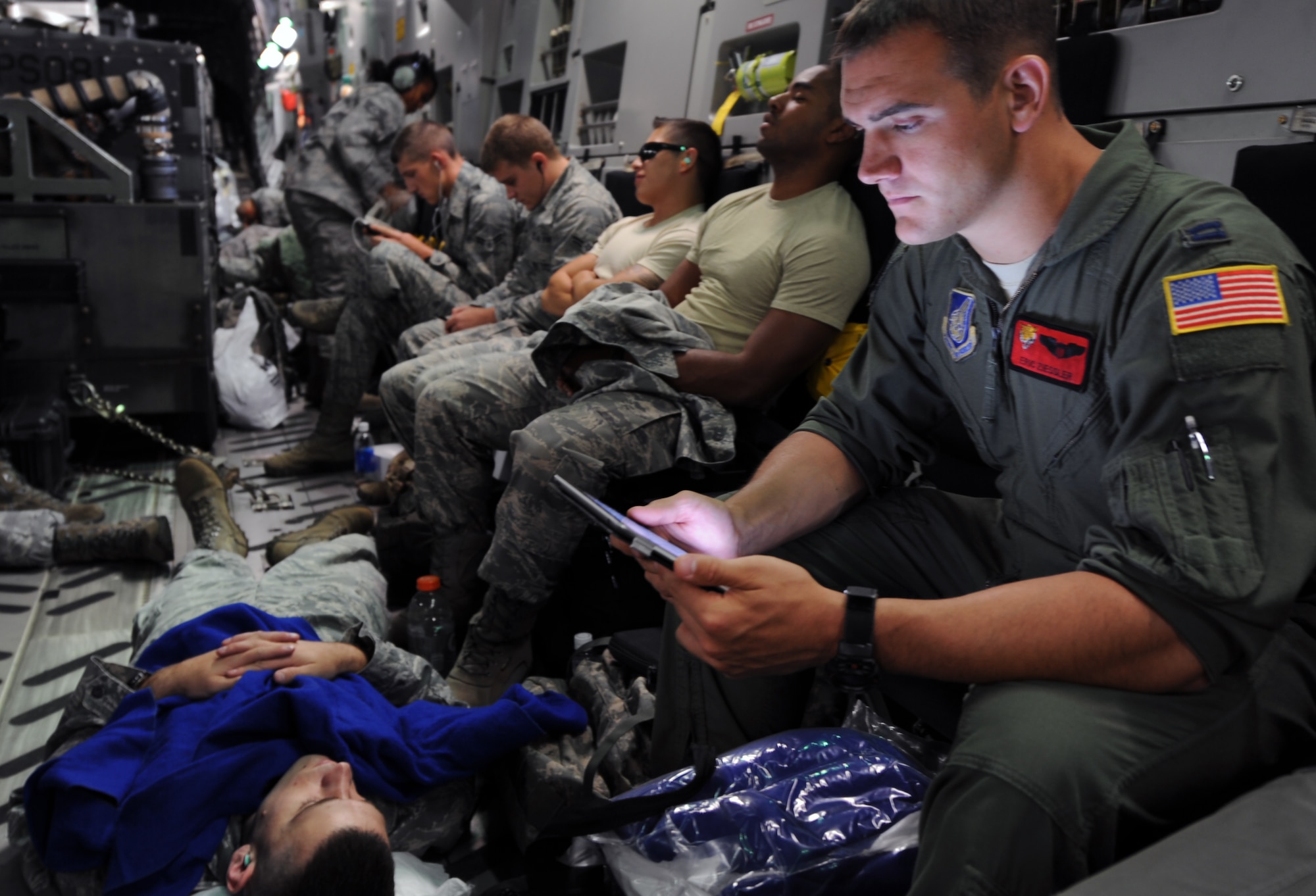 Capt. Eric Ziessler, a pilot from the 535th Airlift Squadron, studies while nearby Airmen get some rest during the seven-hour flight from Joint Base Pearl Harbor-Hickam, Hawaii, to the RED FLAG-Alaska military exercise in Alaska June 6 aboard a C-17 Globemaster III. RED FLAG-Alaska is one of the largest international air-combat employment exercises in the world and is designed to test the specific capabilities of the military units that take part in the exercise and increase their chance of survival during actual combat. (U.S. Air Force photo by Capt. Ben Sakrisson)