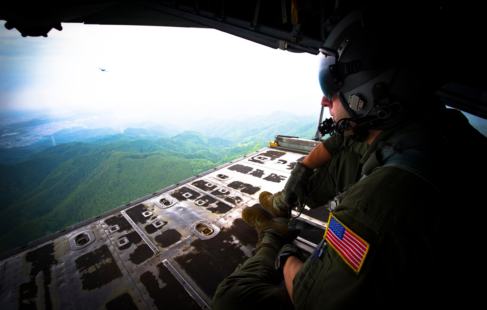 YOKOTA AIR BASE, Japan -- Senior Airman Noel Jones, 36th Airlift Squadron loadmaster, monitors a formation made up of C-130 Hercules cargo aircraft from the ramp of the lead aircraft near Yokota Air Base, Japan, on June 5, 2012. Aircrew from the 36th AS participated in the Samurai Surge, an all-day training exercise testing mission capability of many agencies throughout the base. (U.S. Air Force photo by Staff Sgt. Chad C. Strohmeyer)