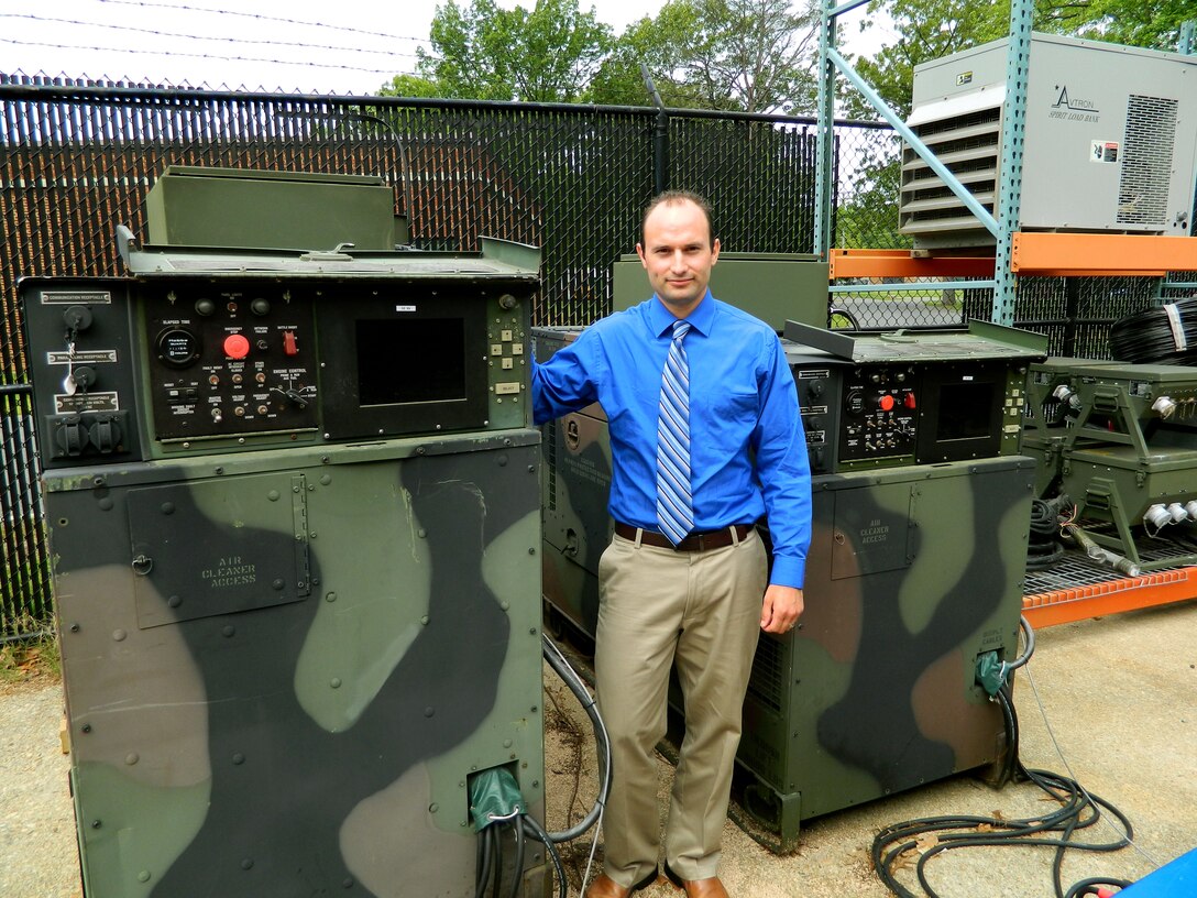 ABERDEEN PROVING GROUND, Md. — Christopher Wildmann, an electrical engineer with the U.S. Army Research, Development and Engineering Command, stands between a 60-kilowatt Tactical Quiet Generator, left, and a 30-kilowatt unit that were modified to enable a microgrid.