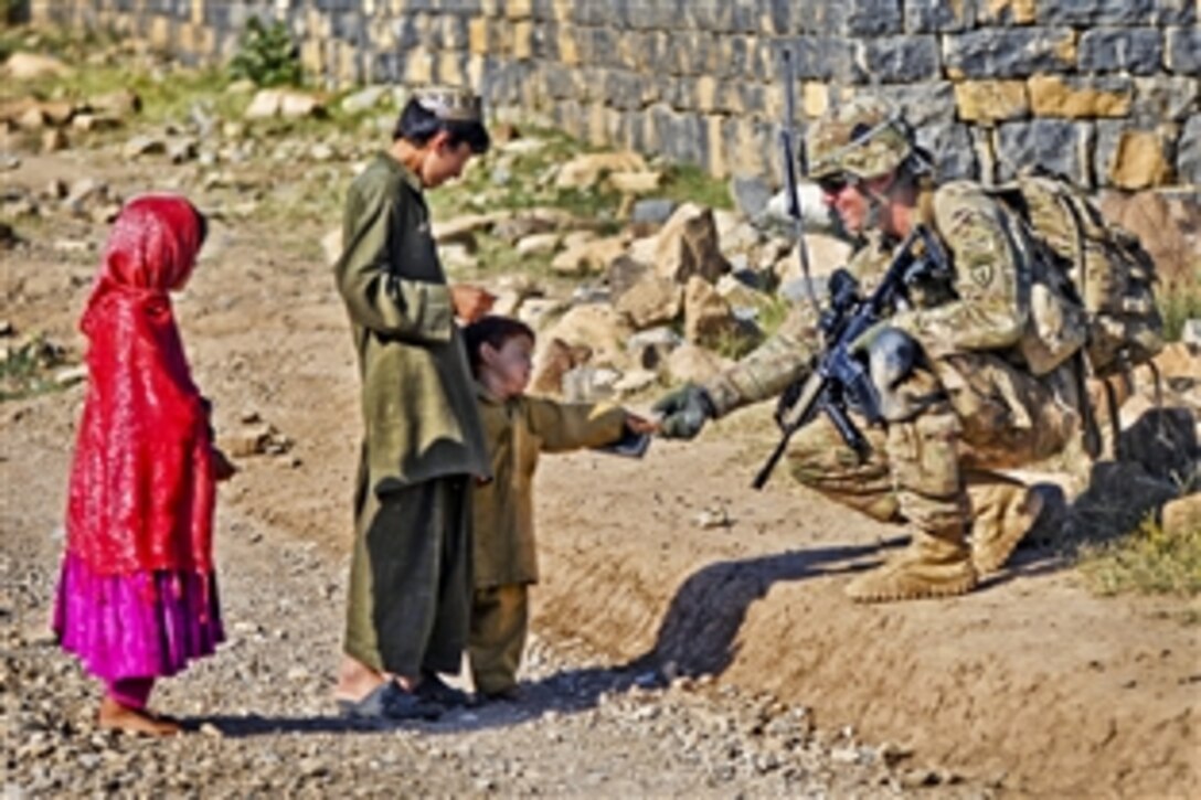 U.S. Army Cpl. Brian Lewis greats an Afghan boy while conducting a dismounted patrol in Shaway Valley in Afghanistan's Khowst province, June 2, 2012. Lewis, a team leader, is assigned to Company B, 1st Battalion, 501st Infantry Regiment.