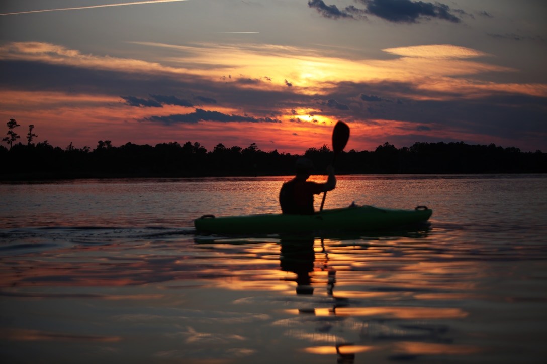 Retired Lt. Col. Gerald Harper paddles his way up the New River while enjoying a summer sunset during Outdoor Adventures moonlight kayaking event June 3.