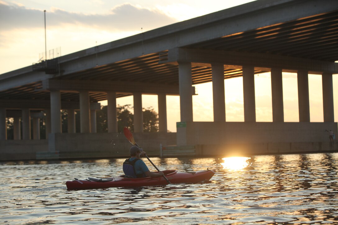 Marybeth LeMaire makes her way underneath the KIA/MIA/POW bridge while leading a tour up the New River during a moonlight kayaking event in Jacksonville, N.C., June 3.