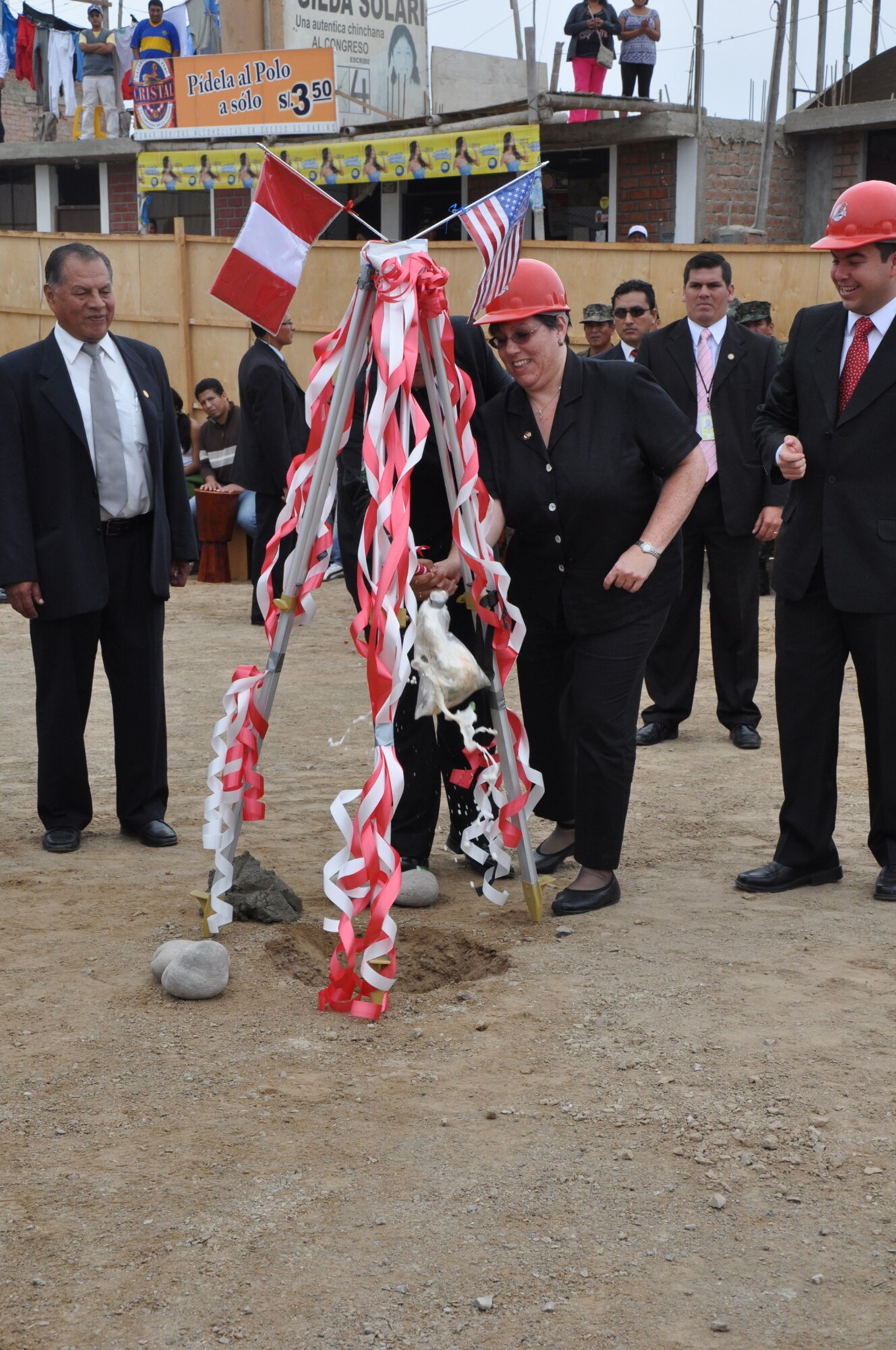TAMBO DE MORA, Peru- The U.S. ambassador, Rose Linkin, breaks the champagne bottle with a hammer as part of the traditional groundbreaking in Peru during the opening ceremony June 5. The ceremonial groundbreaking also includes the VIP party to shovel cement in the ground to officially commemorate the event. (U.S. Air Force photo/Senior Airman Melissa Dearstone)