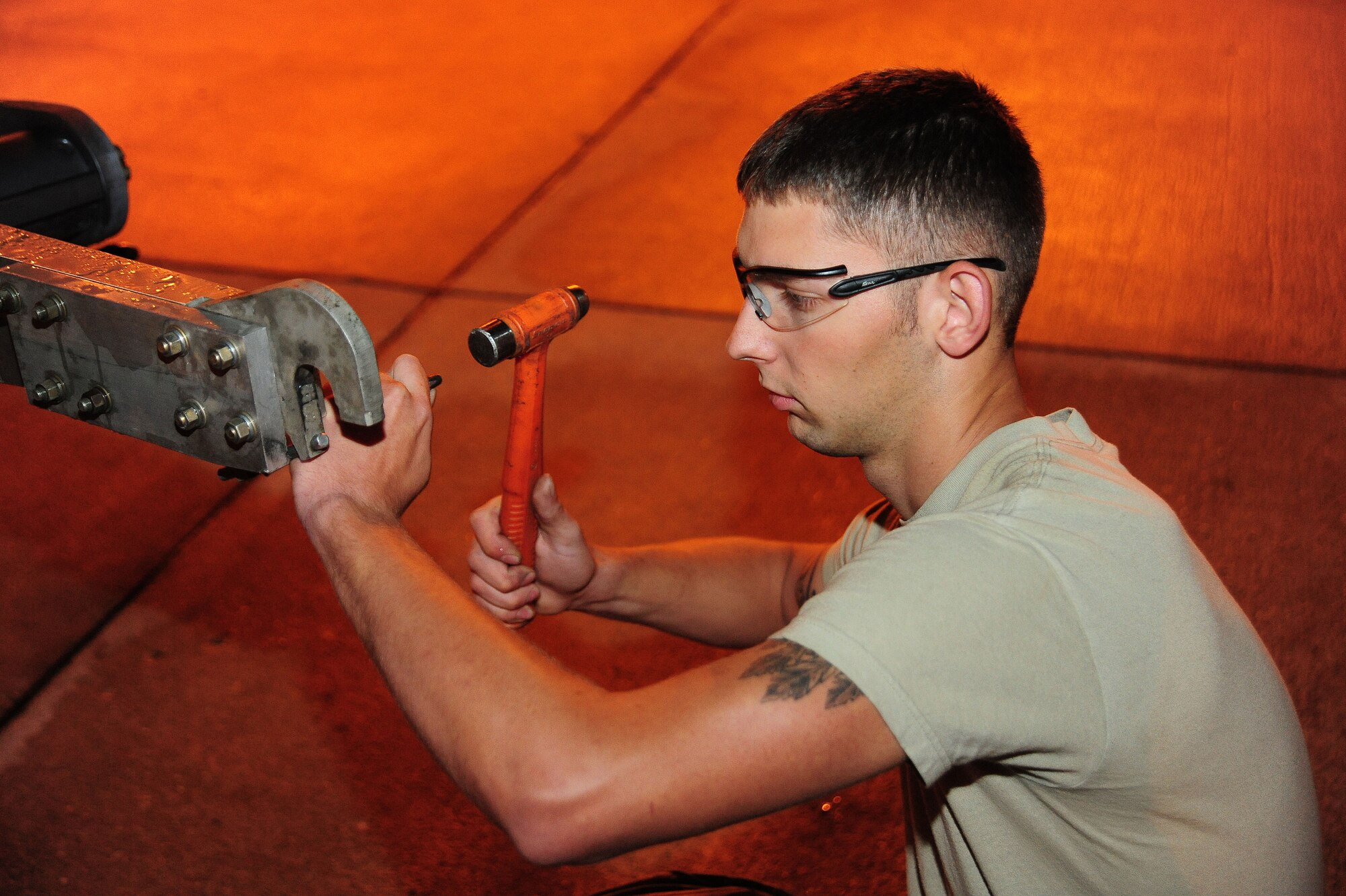 WHITEMAN AIR FORCE BASE, Mo. -- Senior Airman John McLaughlin, 509th MXS Aerospace Ground Equipment journeyman, uses a hammer to remove a pin on a MD-1 towbar during a service inspection May 31, 2012. Airmen from the AGE flight are responsible for supplying maintenance equipment that service aircraft on the flightline. (U.S. Air Force photo/Senior Airman Nick Wilson) (Released)