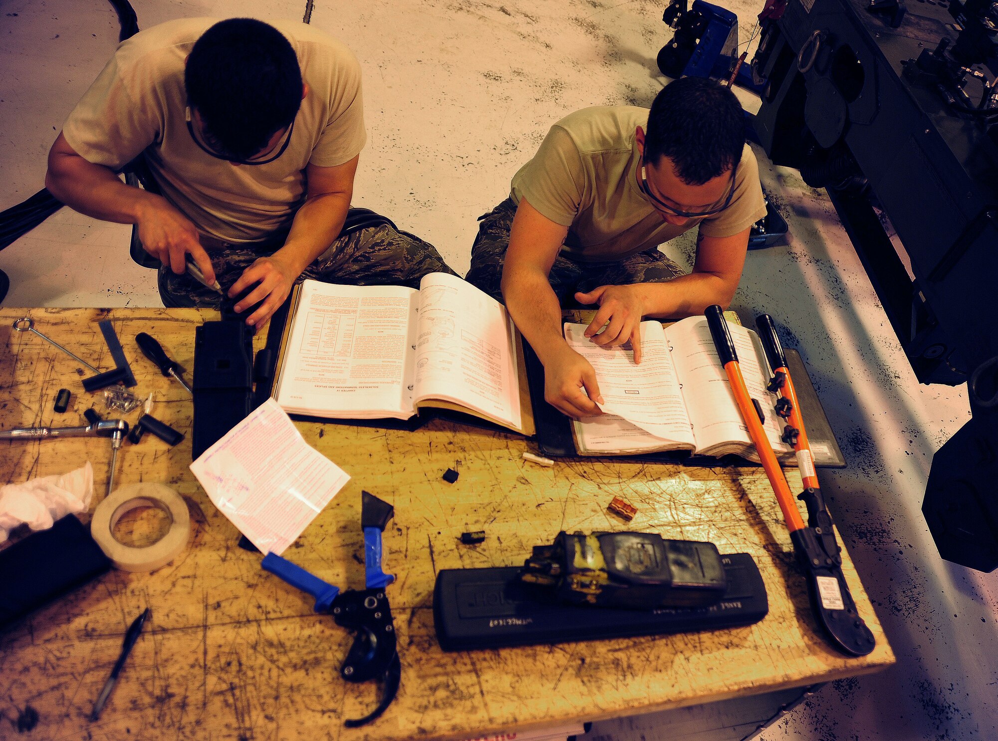WHITEMAN AIR FORCE BASE, Mo. -- Airman 1st Class James McQueen, 509th Maintenance Squadron Aerospace Ground Equipment apprentice, and Senior Airman Coty Cloud, 509th MXS Aerospace Ground Equipment journeyman, use a technical order to ensure proper steps are being performed during maintenance May 31, 2012. Every piece of equipment the AGE flight services is accompanied by a technical order, which provides step-by-step procedures for all types of maintenance. (U.S. Air Force photo/Senior Airman Nick Wilson) (Released)