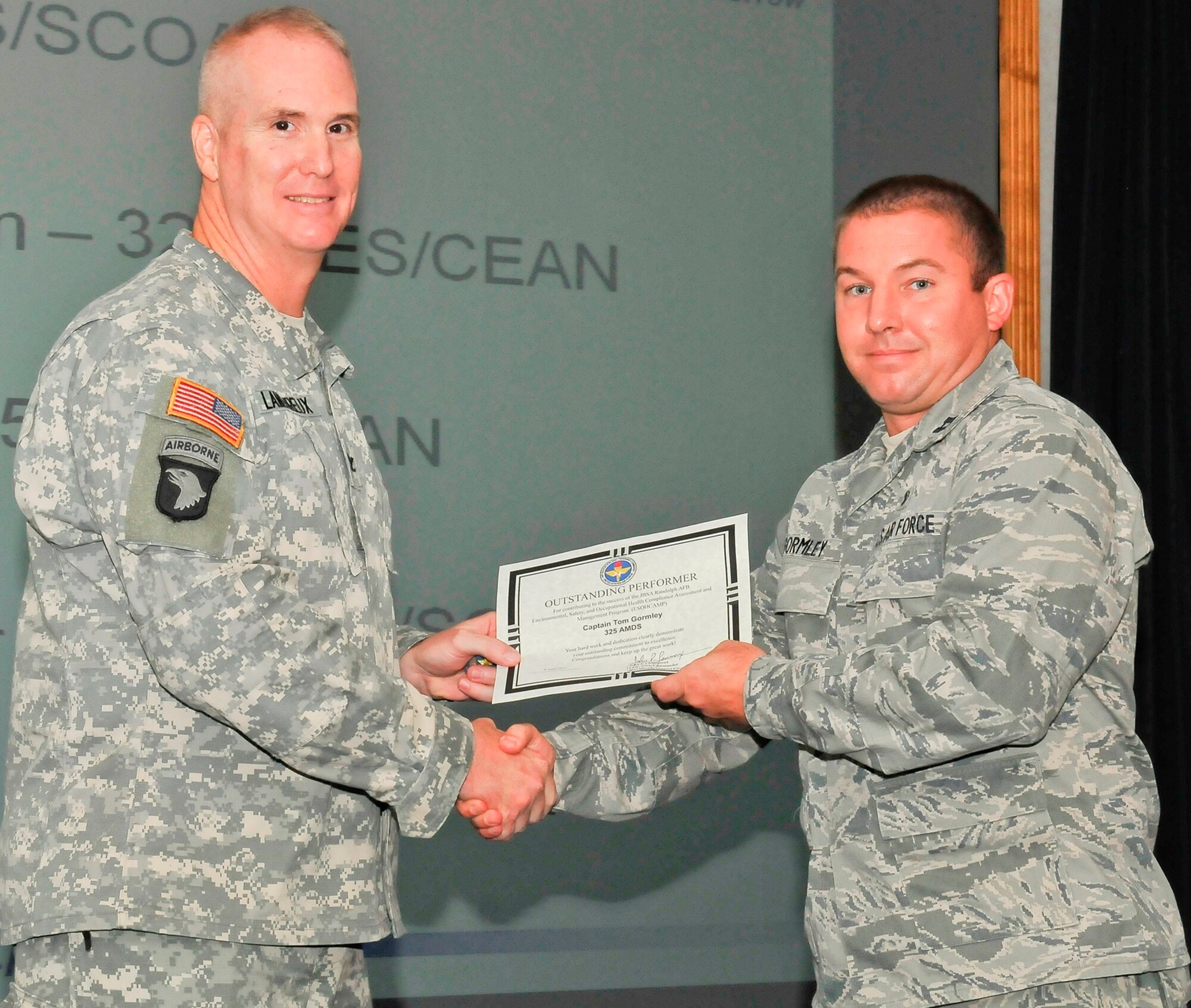Army Col. John Lamoreux, 502nd Mission Support Group commander, Joint Base San Antonio, Texas, and the ESOCHCAMP command representative, presented Capt. Tom Gormley, 325th Aerospace Medicine Squadron occupational and environmental health element chief, an outstanding performance award for the Tyndall 2012 Environmental, Safety and Occupational Health Compliance Assessment Management Program Inspection during the outbrief June 8. (U.S. Air Force photo by Chris Cokeing)