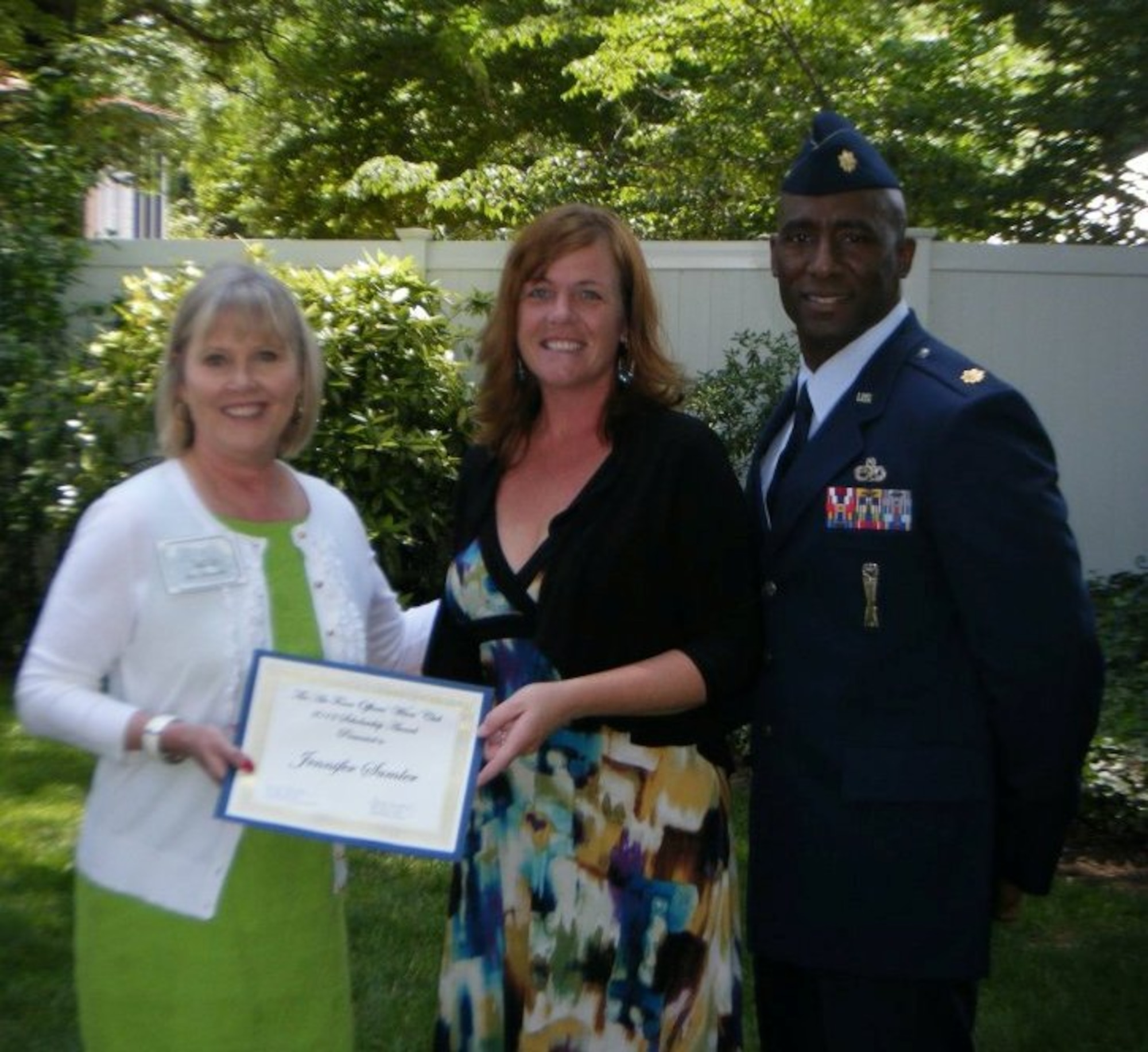 Mrs. Suzie Schwartz, wife of the Air Force Chief of Staff, General Norton Schwartz, and honorary president of the Air Force Officers’ Wives’ Club of Washington, D.C  presents a certificate to Mrs. Jennifer Sumler with her husband, Major Kenneth Sumler. 