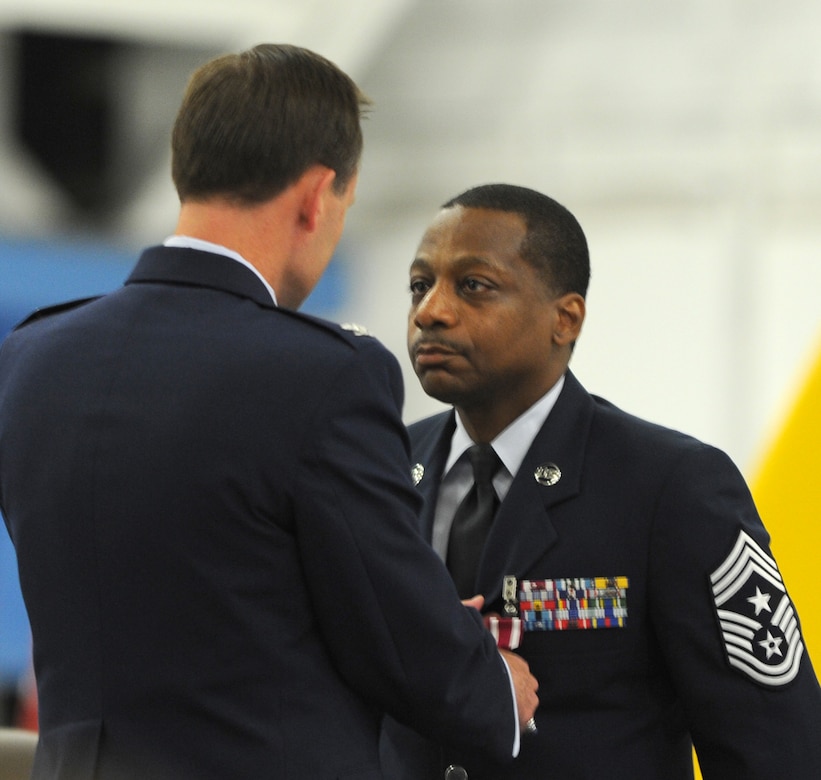 Colonel Ken Rizer, 11th Wing/Joint Base Andrews commander, presents Chief Master Sgt. Anthony Brinkley, 11th Wing/Joint Base Andrews command chief, with a medal during Brinkley's retirement ceremony June 8, 2012.  Brinkley served more than 28 years in the Air Force.  (U.S. Air Force Photo by Staff Sgt. Torey Griffith)