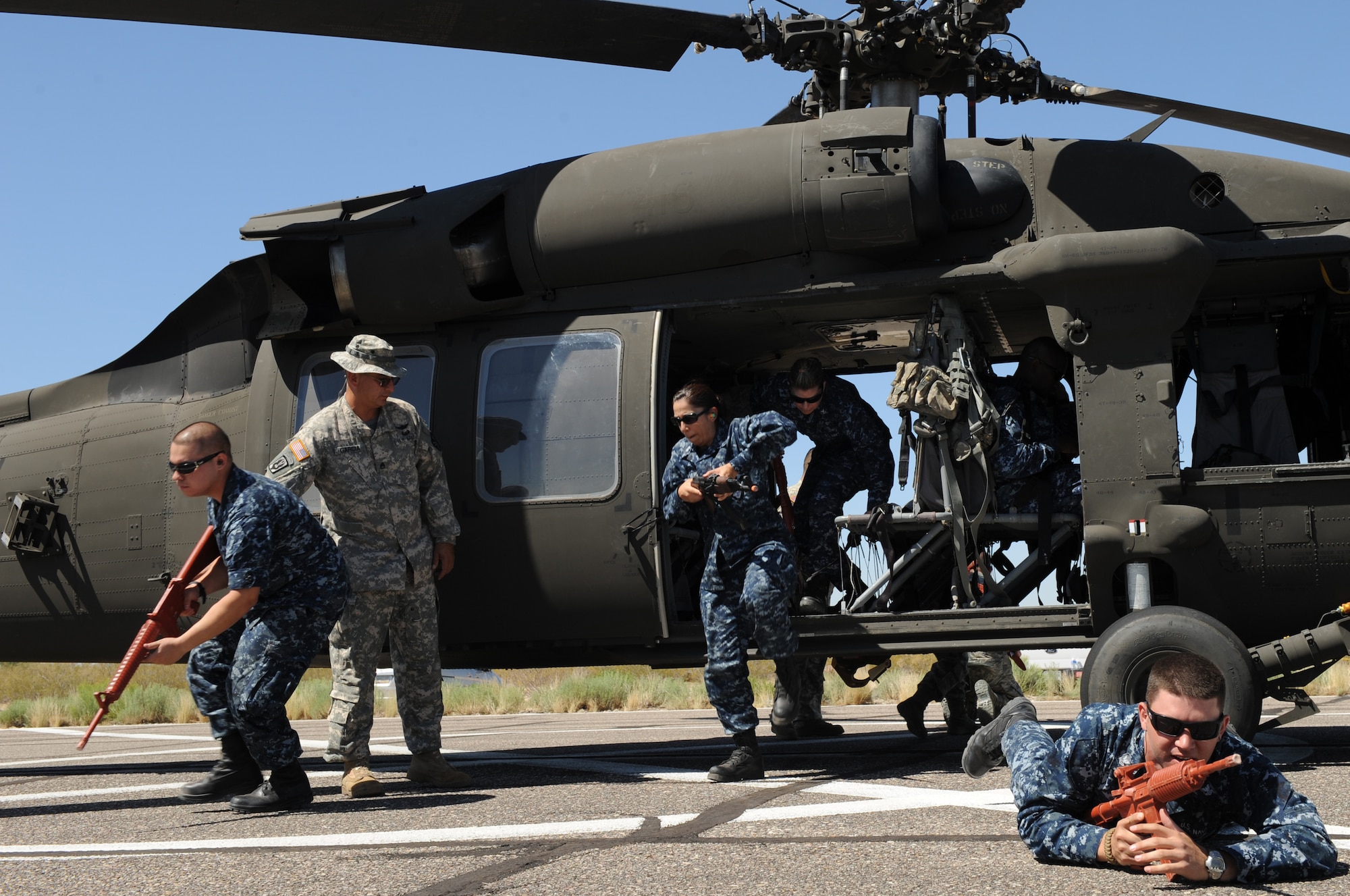 Members of the U.S. Navy learn how provide cover for a UH-60 Black Hawk during helicopter pre-deployment training at Davis-Monthan Air Force Base, Ariz. June 7. This training was to prepare Airmen, Marines, soldiers and sailors for actions they might experience in combat. (U.S. Air Force photo by Senior Airman Brittany Dowdle/released)