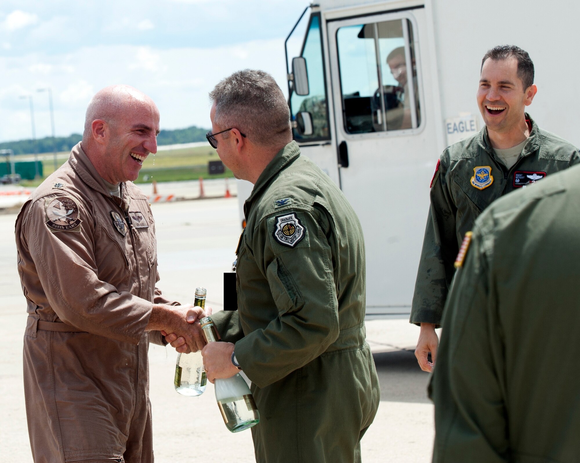 Col. Paul Murphy, 305th Air Mobility Wing commander welcomes Lt. Col. Ken Moss, 908th Expeditionary Air Refueling commander back from a one-year deployment June 7 here. The men and women of the 305th Air Mobility Wing, 514th AMW and 87th Air Base welcomed Moss back to the United States after he completed his “fini” flight in a KC-10 Extender. The greeters welcomed Moss and the returning JB MDL-based flyers and maintainers with the traditional fire truck spray down before spraying Moss with champagne. Moss is deployed from Travis Air Force Base, Calif. (U.S. Air Force photo by Wayne Russel/Released)