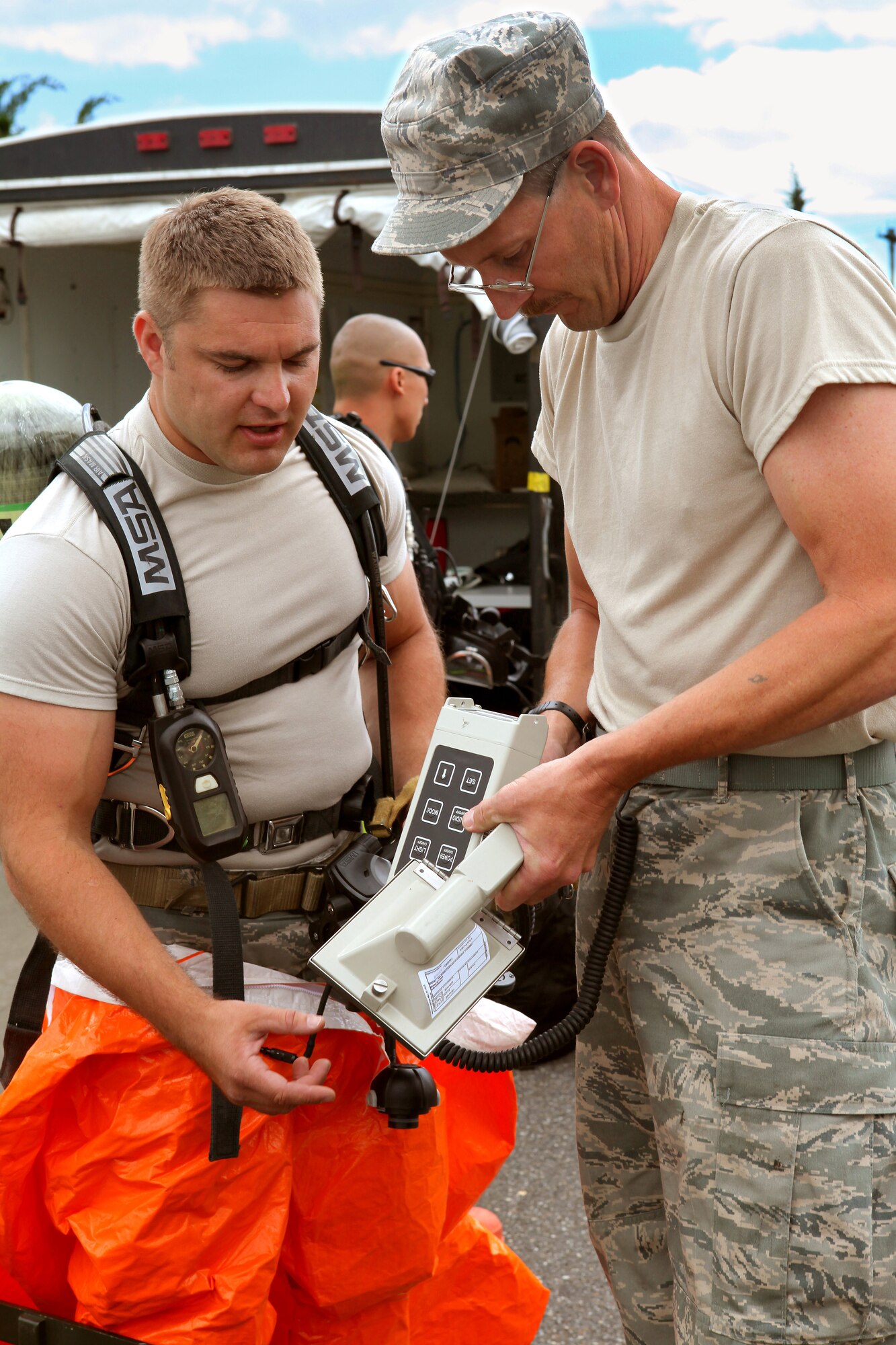 A picture of Explosive Ordnance Disposal non-commissioned officer in charge Master Sgt. Ed Nickel helping Tech. Sgt. David Niedzwiadek with a ADM-300 radiological detector.