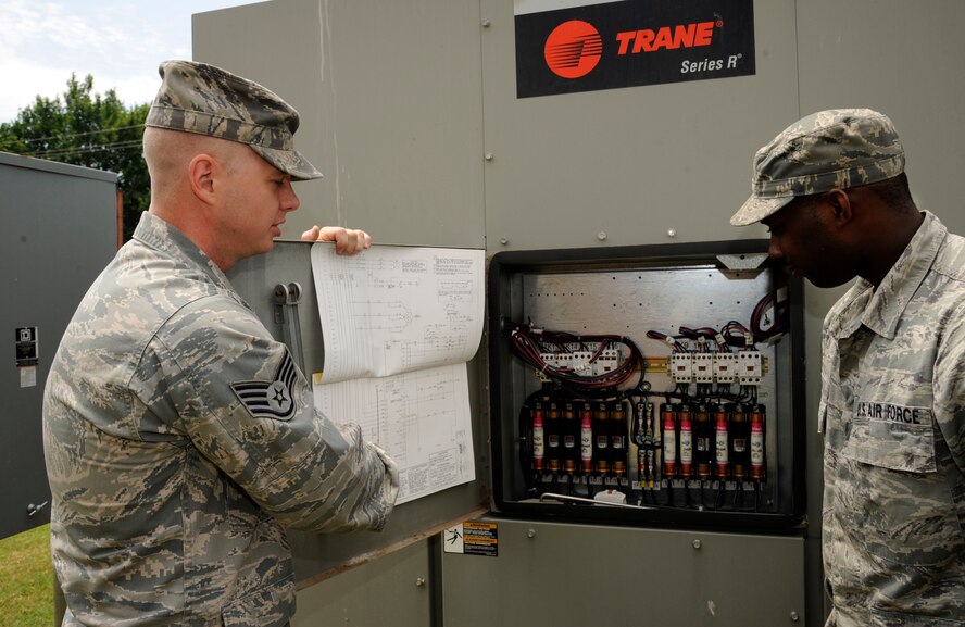Staff Sgt. Nathan Day and Senior Airman Ricky Ball, 2nd Civil Engineer Squadron Heating, Ventilation, Air Conditioning and Refrigeration technicians, review schematics for one of the recently installed chillers on Barksdale Air Force Base, La., June 7. New heating and cooling units are routinely brought in when needed and installed to maintain Barksdale?s aging heating and cooling systems. (U.S. Air Force photo/Airman 1st Class Andrew Moua)(RELEASED)