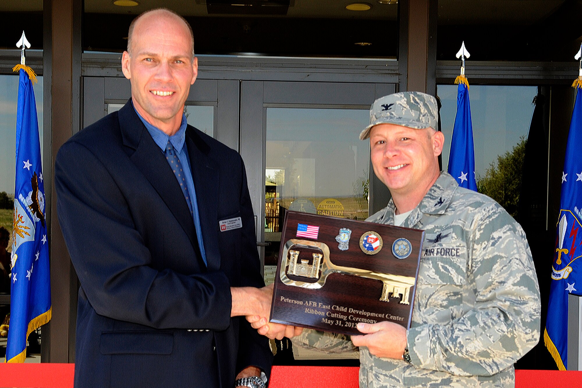 The ceremonial key to the new Child Development Center annex was presented to Col. Chris Crawford, 21st Space Wing commander, by Brian Dziekonski, United States Army Corp of Engineers Rocky Mountain Area, at the ribbon cutting ceremony of the newly opened building at Peterson East on May 31. (U.S. Air Force photo illustration/Rob Bussard)