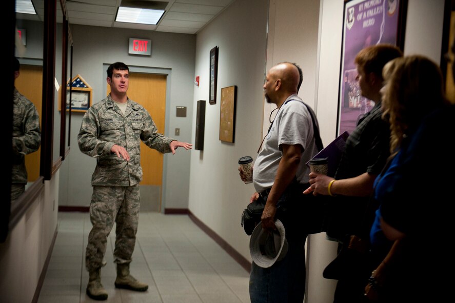 U.S. Air Force Capt. Daniel Catino, 38th Rescue Squadron combat rescue officer, explains the history behind some pararescueman memorabilia to Air Force Art Program Artists during their tour of Moody Air Force Base, Ga., June 8, 2012. The artists spent four days at Moody and visited various units to gain a better understanding of the base’s mission with plans on creating artwork featuring Moody Airmen and assets. (U.S. Air Force photo by Staff Sgt. Jamal D. Sutter/Released)