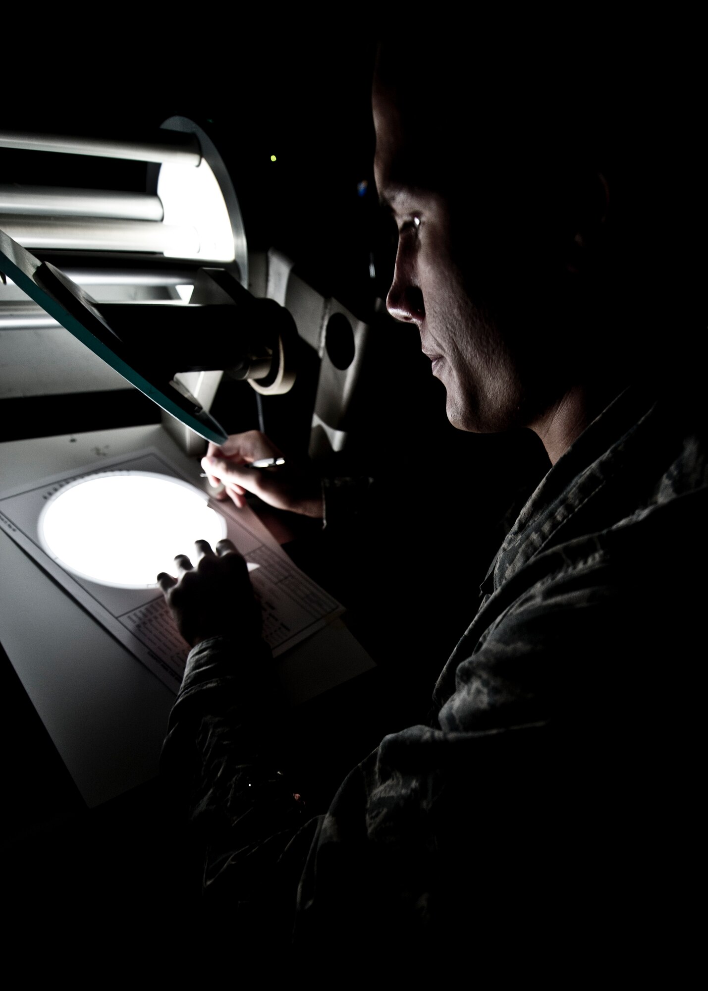 Senior Airman Erin O’Connell, Detachment 4, 2nd Weather Squadron solar analyst, uses a white light board to observe the size of solar spots on the sun at the Holloman Air Force Base, N.M., solar observatory June 7. Although many spots appear small when projected by the machine, solar analysts use scales to show how massive the spots are in comparison to other planets. (U.S. Air Force photo by Airman 1st Class Daniel E. Liddicoet/Released)
